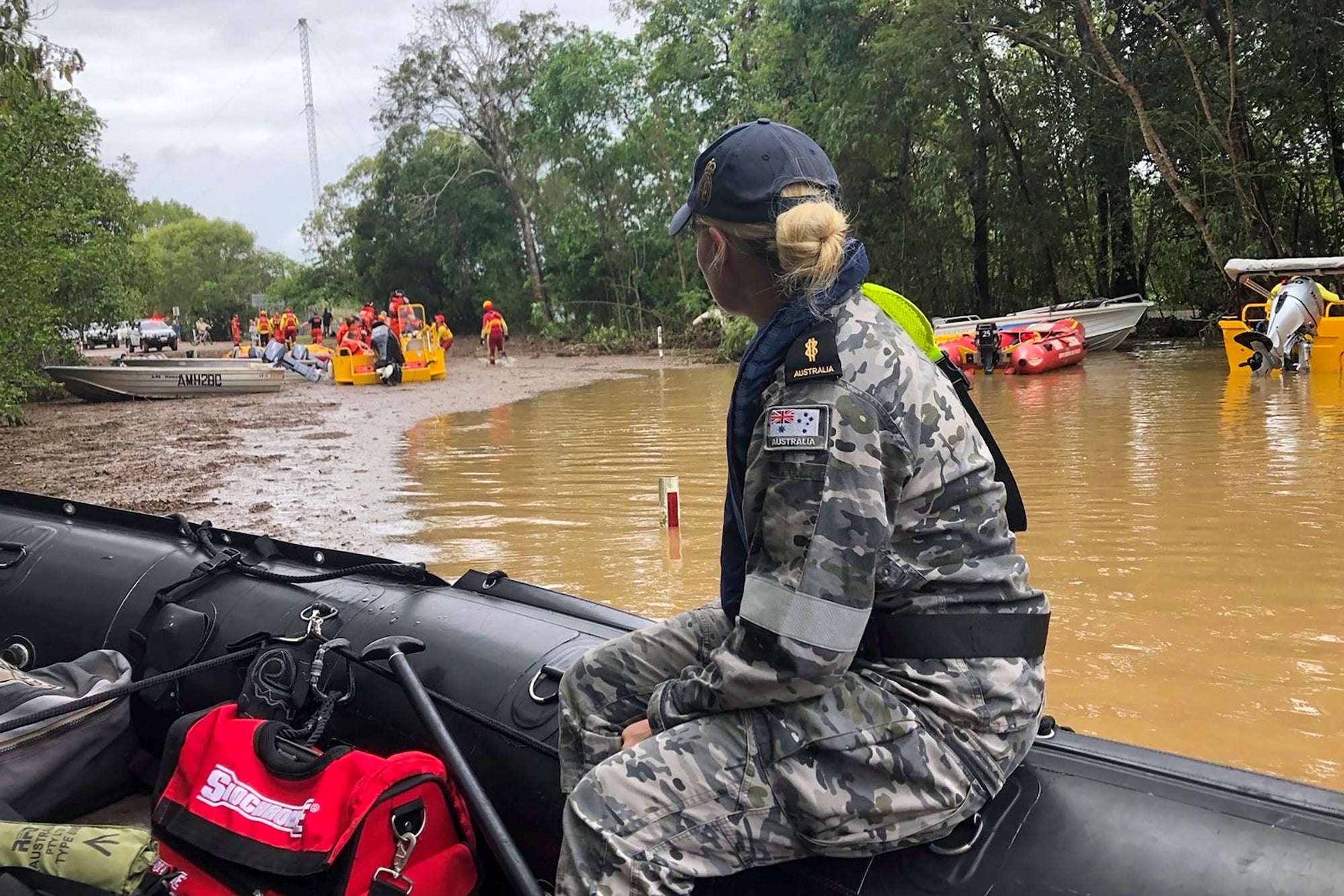 Royal Australian Navy personnel work with emergency services to evacuate residents in Cairns, Australia