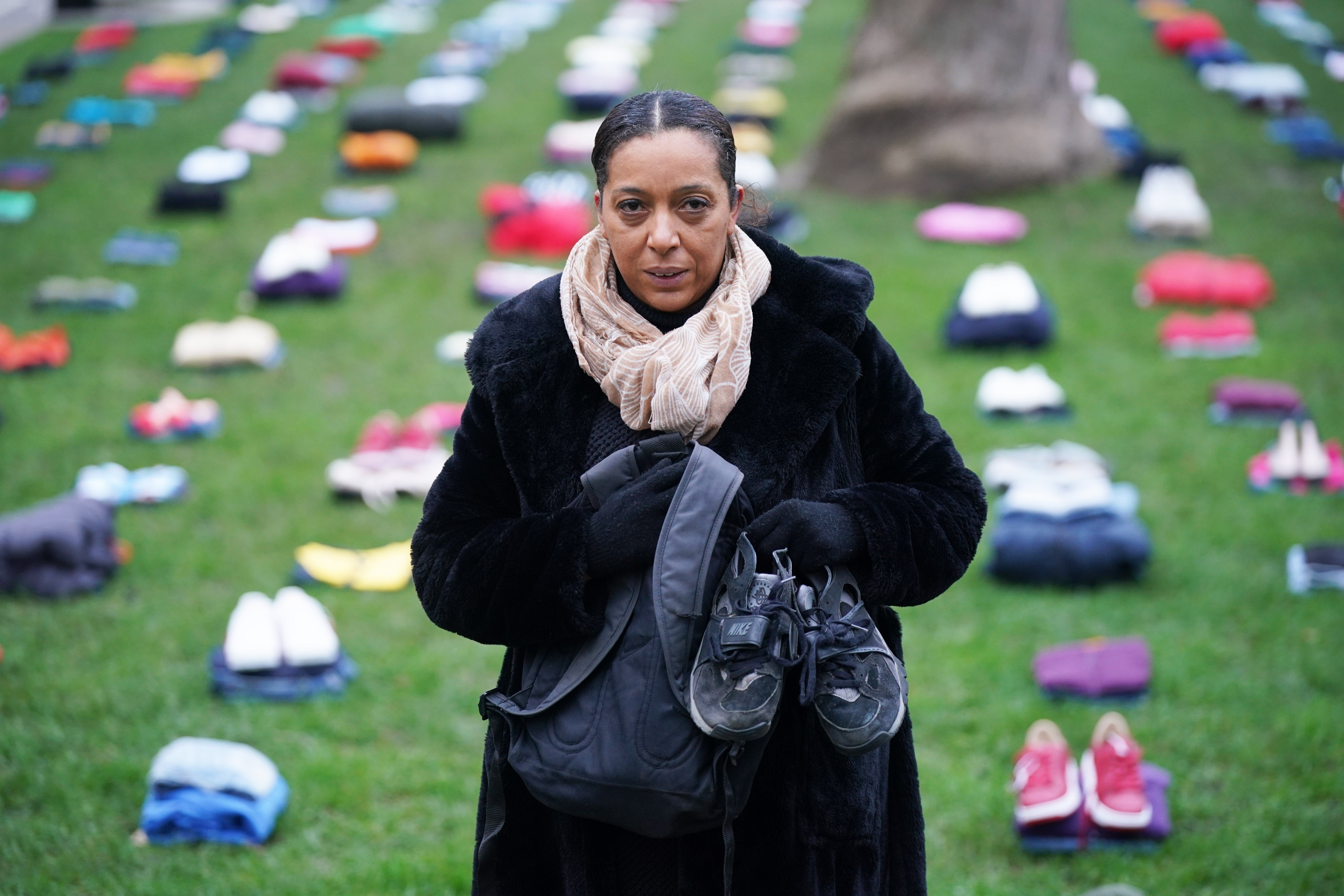 Yemi Hughes holds the clothes that her son Andre Aderemi, 19, was wearing when he was stabbed to death in Croydon in 2016