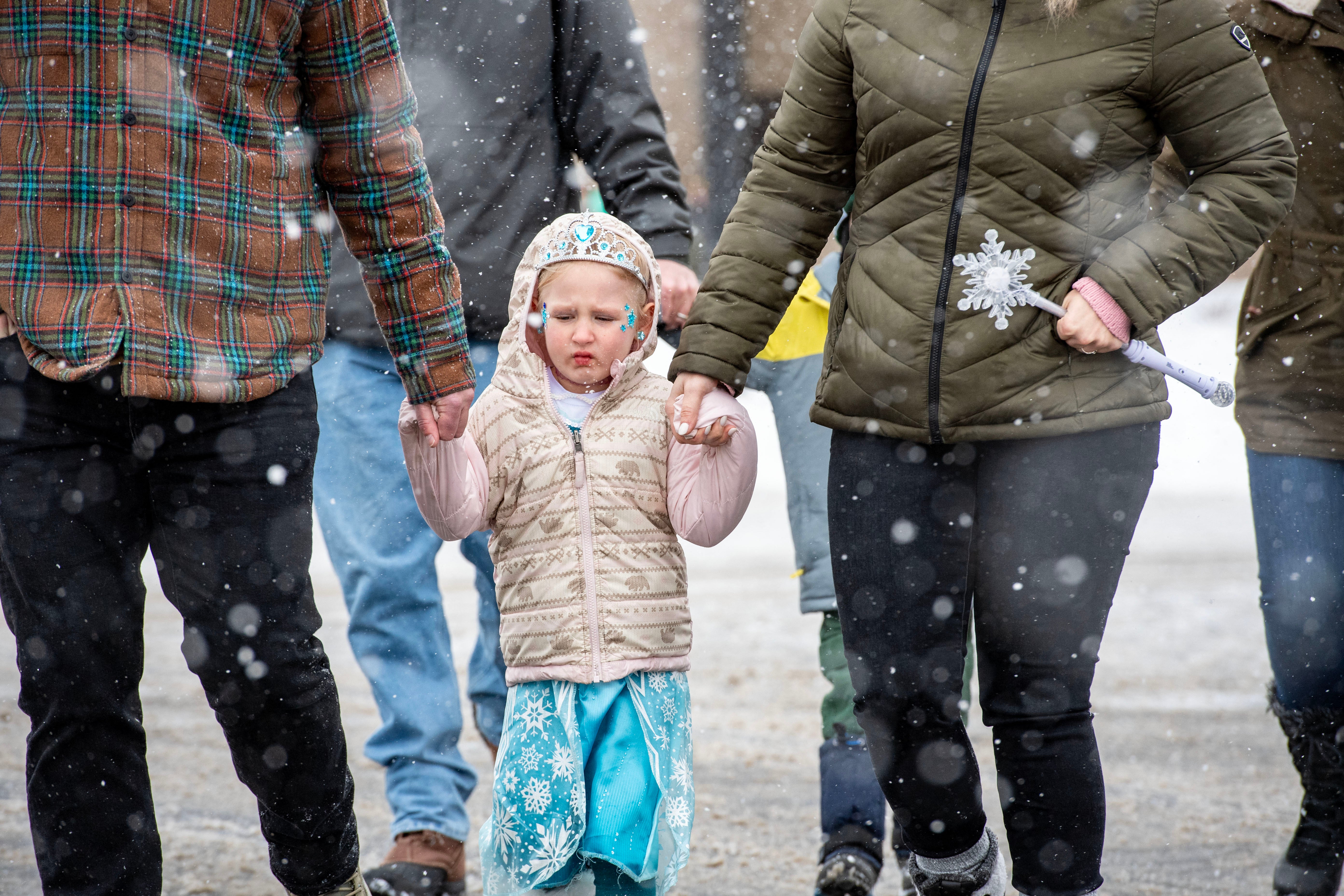 People make their way across the snowy street to the Southern New Hampshire University Arena to see a show in Manchester, New Hampshire