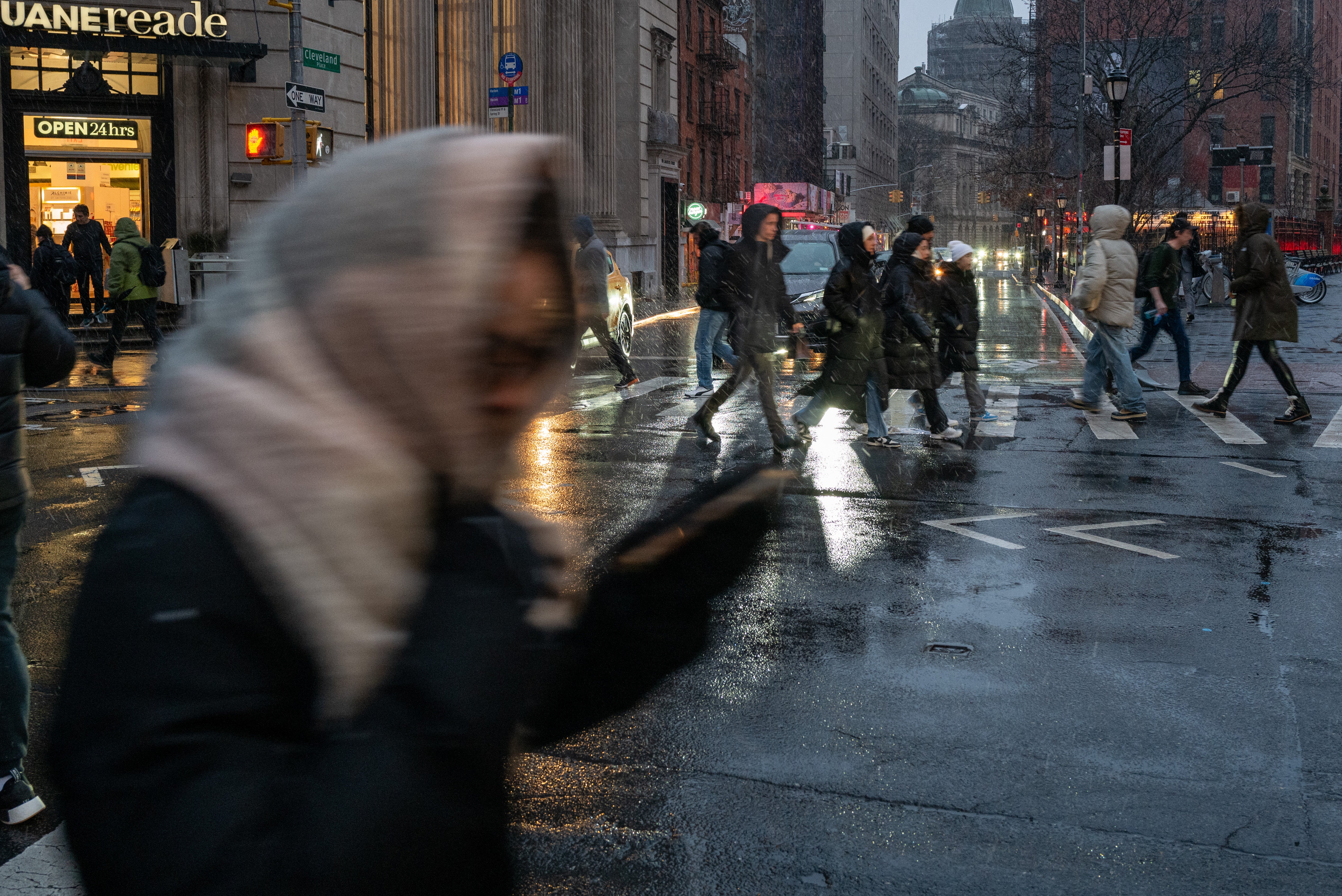 People walk through New York City amid wintry precipitation on 6 January