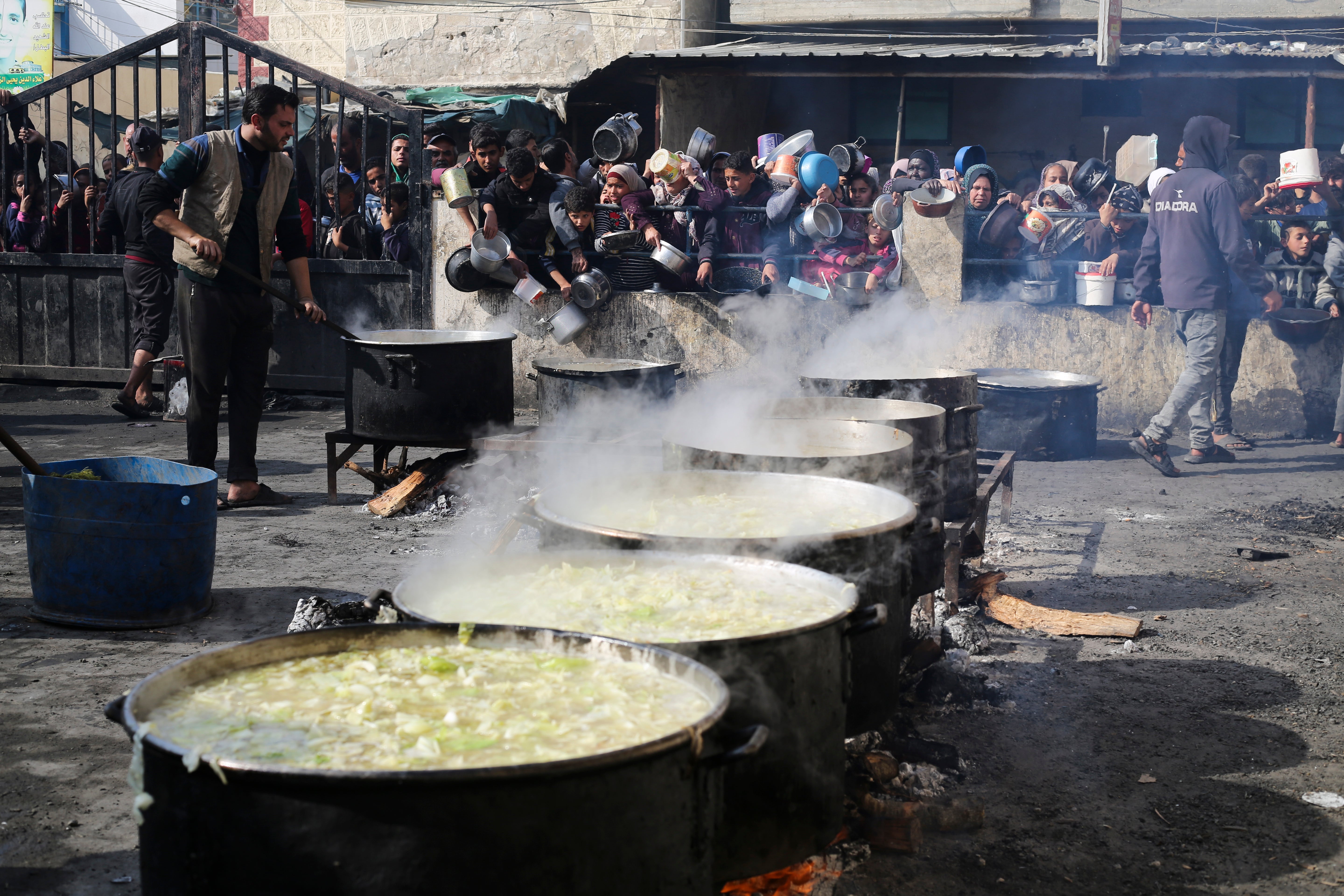 Palestinians line up for free food during the ongoing Israeli air and ground offensive