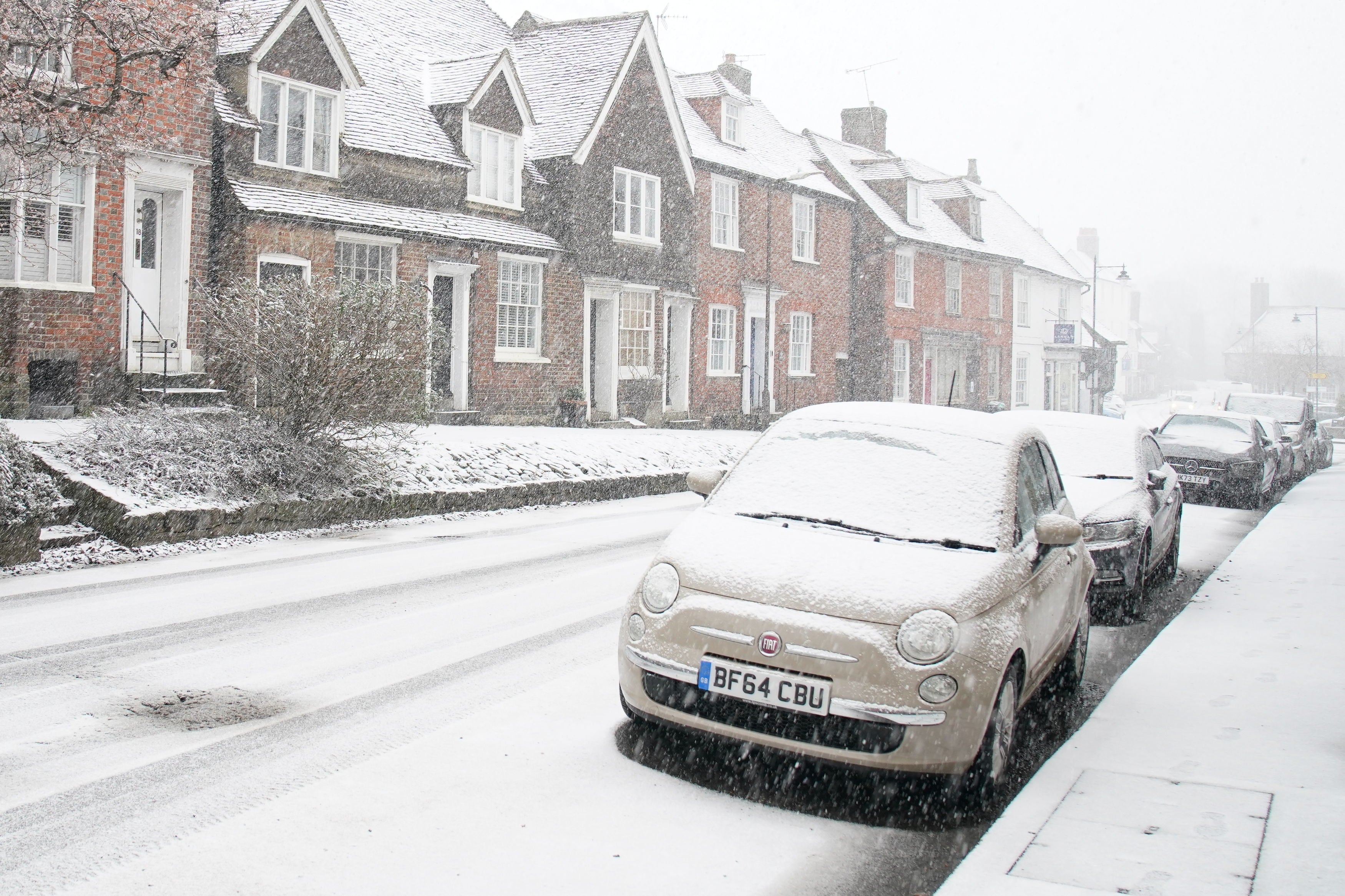 Cars parked during a snow flurry in Lenham, Kent, on Monday