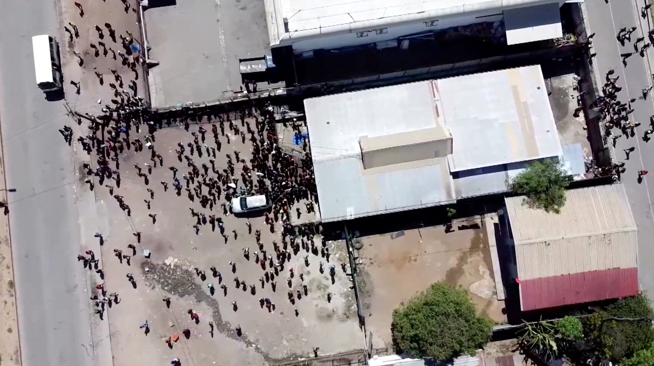 People gather near a building, amid reports of widespread looting and arson as police and the public sector protest over a pay cut that officials blamed on an administrative glitch, in Port Moresby