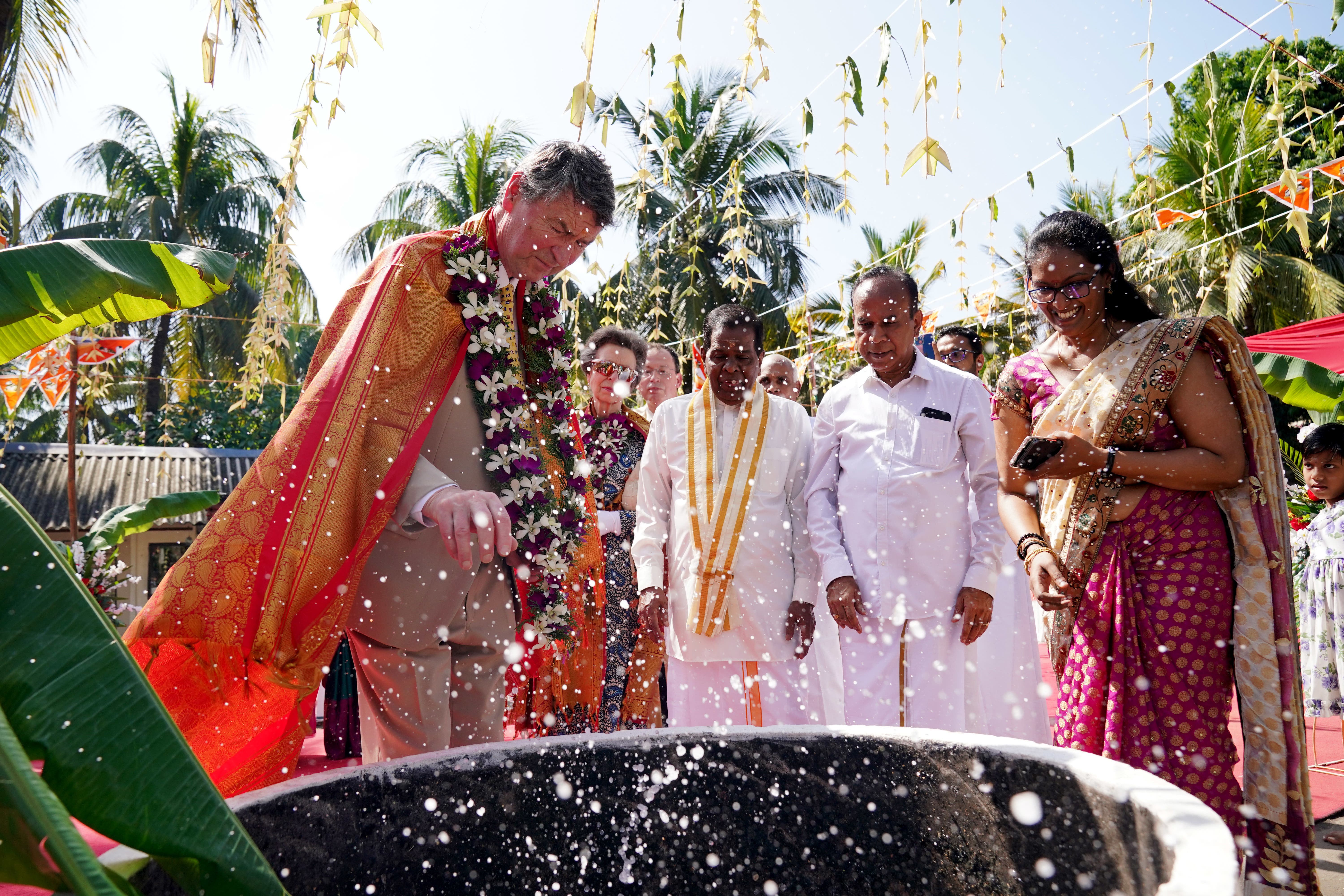 Vice Admiral Sir Timothy Laurence smashes a coconut during a visit to Vajira Pillayar Kovil Hindu temple in Colombo, Sri Lanka (Jonathan Brady/PA)