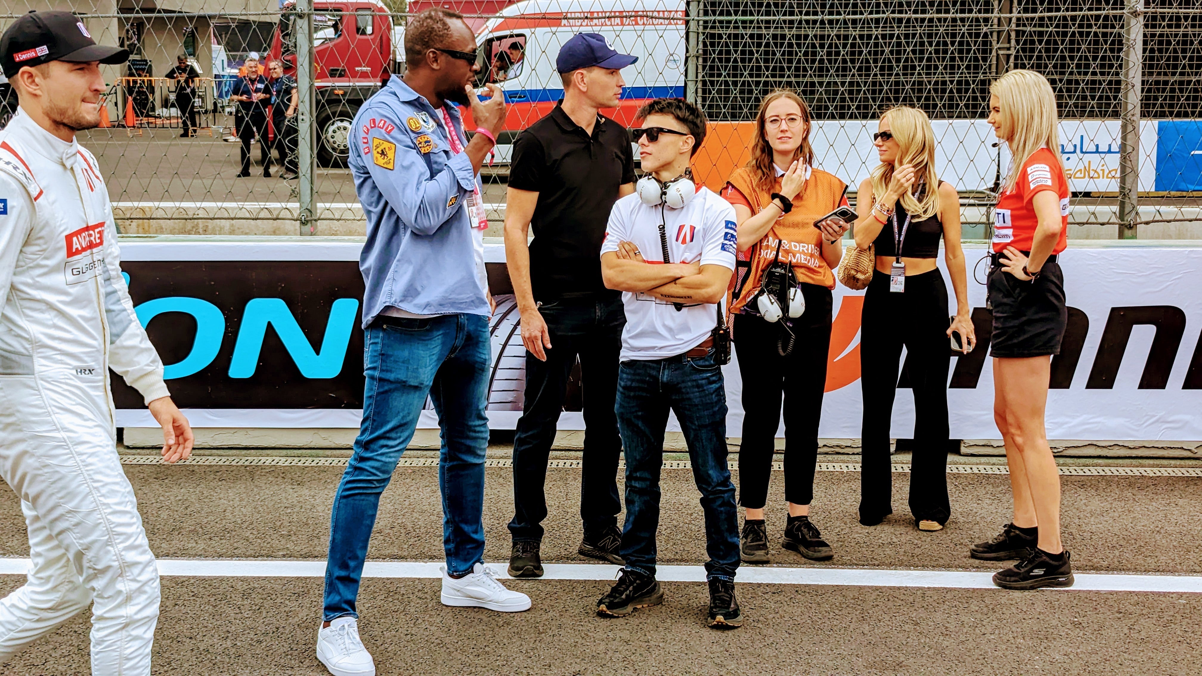 Jake Dennis (left) heads to his car as Usain Bolt walks the Formula E grid prior to the race in Mexico City