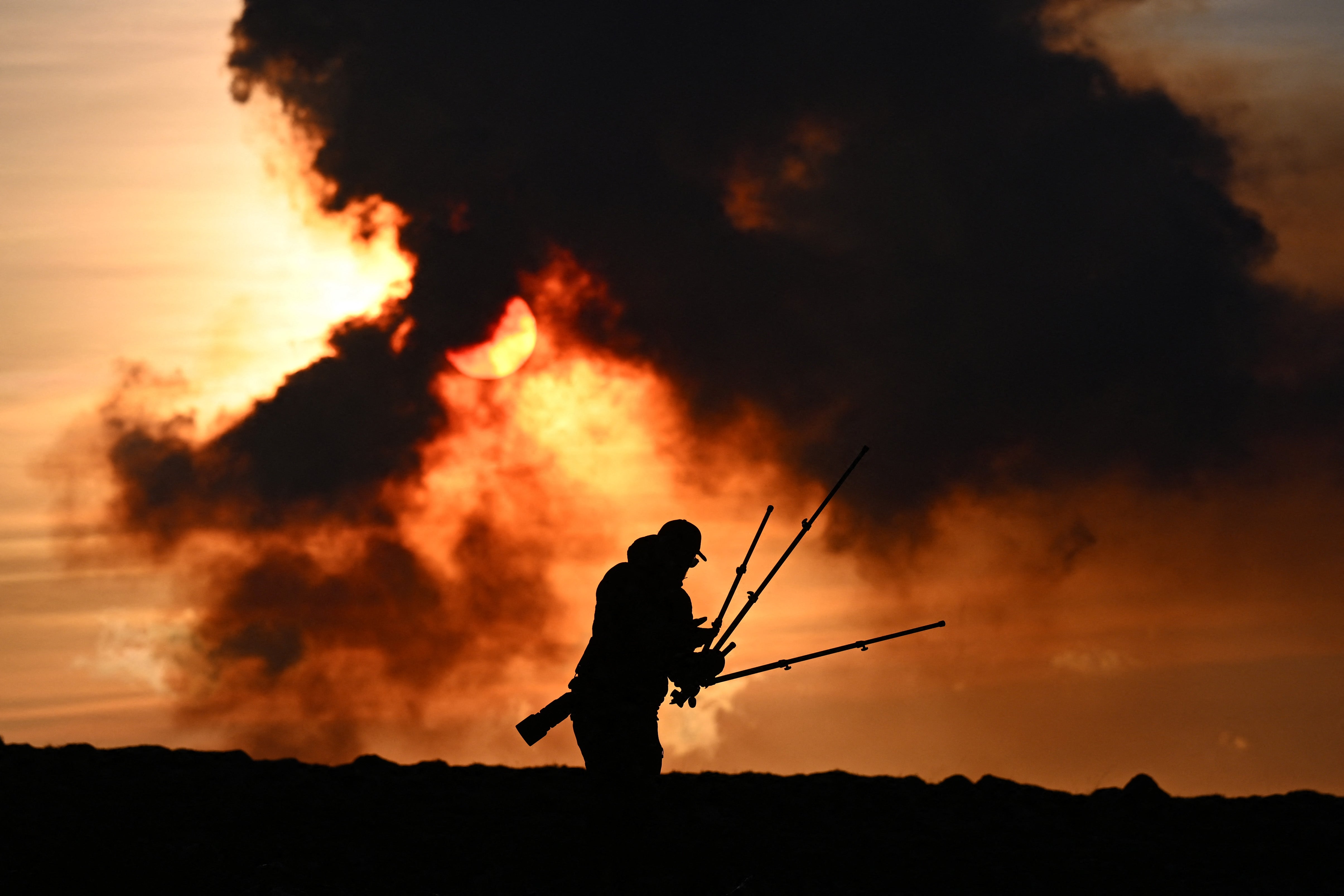 A man adjusts his photographic equipment near Keflavik