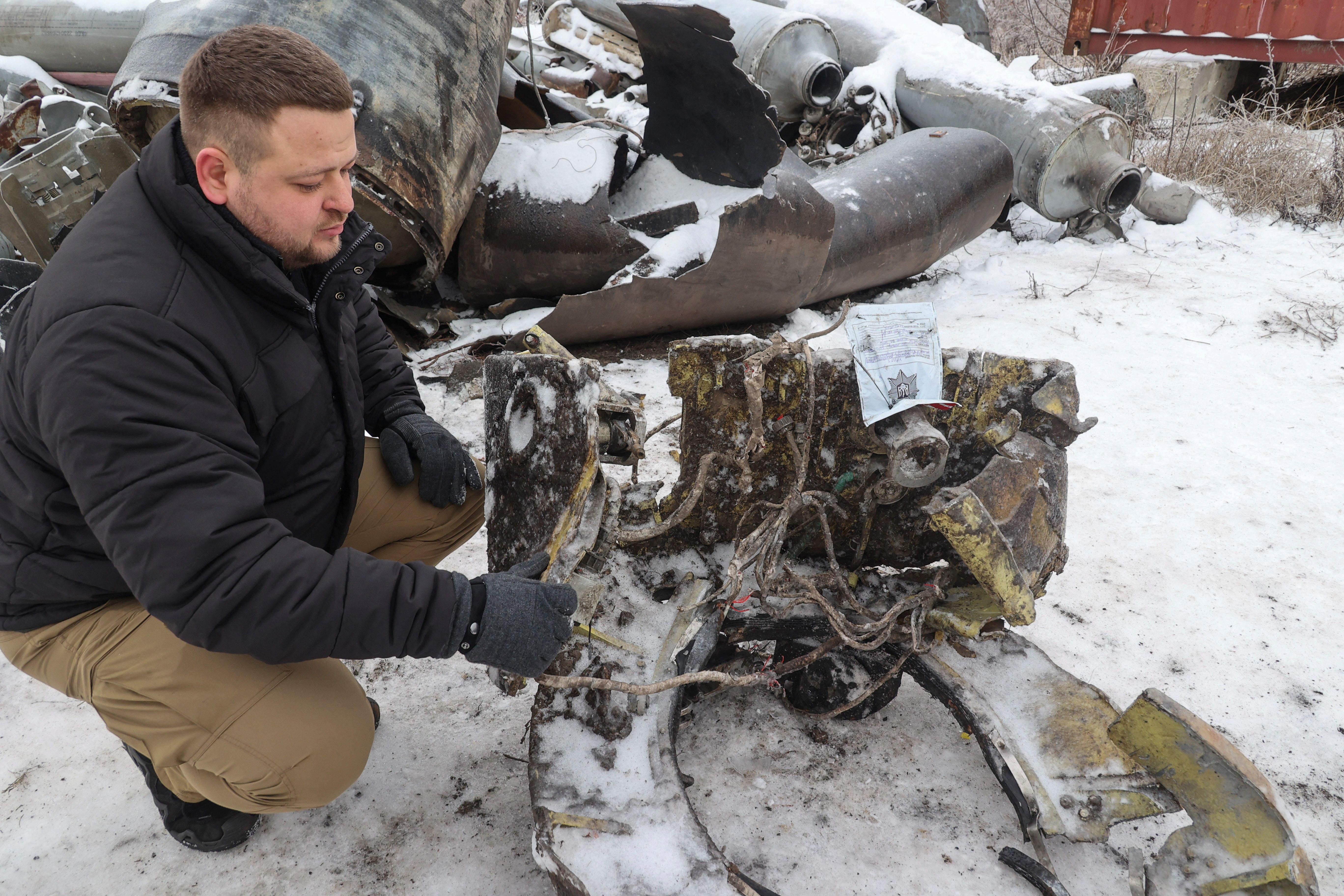 A Ukrainian official shows parts of an unidentified missile suspected to have been made in North Korea and used in a Russian strike on Kharkiv