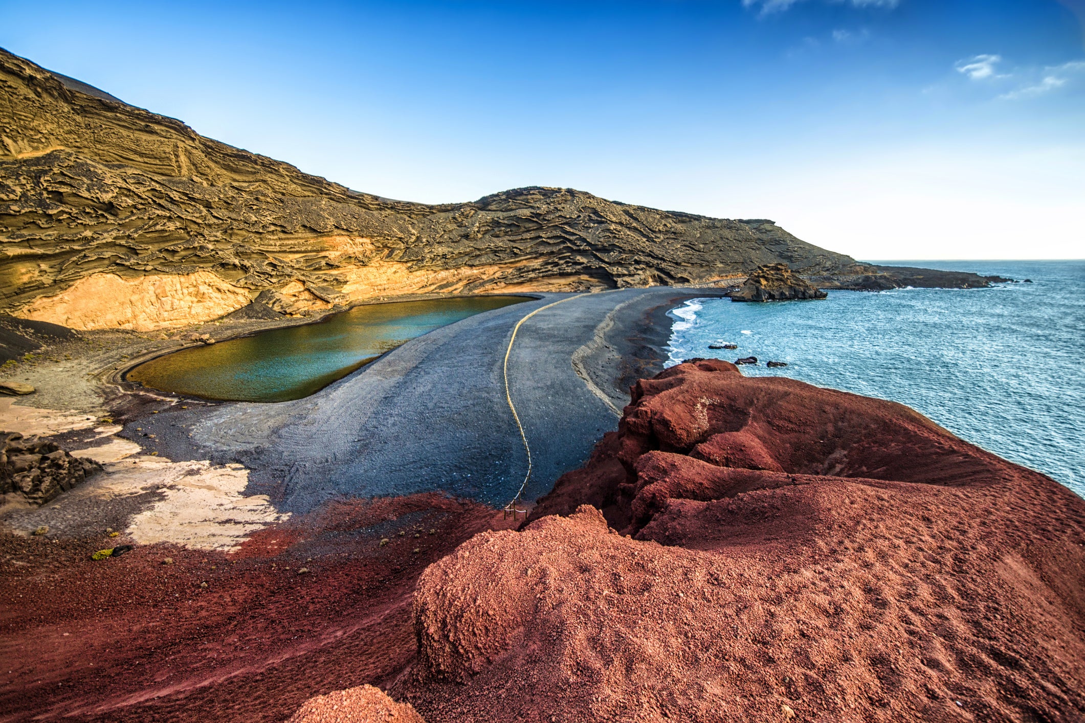 Volcanic black sand meets an algae-green lagoon at Charco de Los Clicos