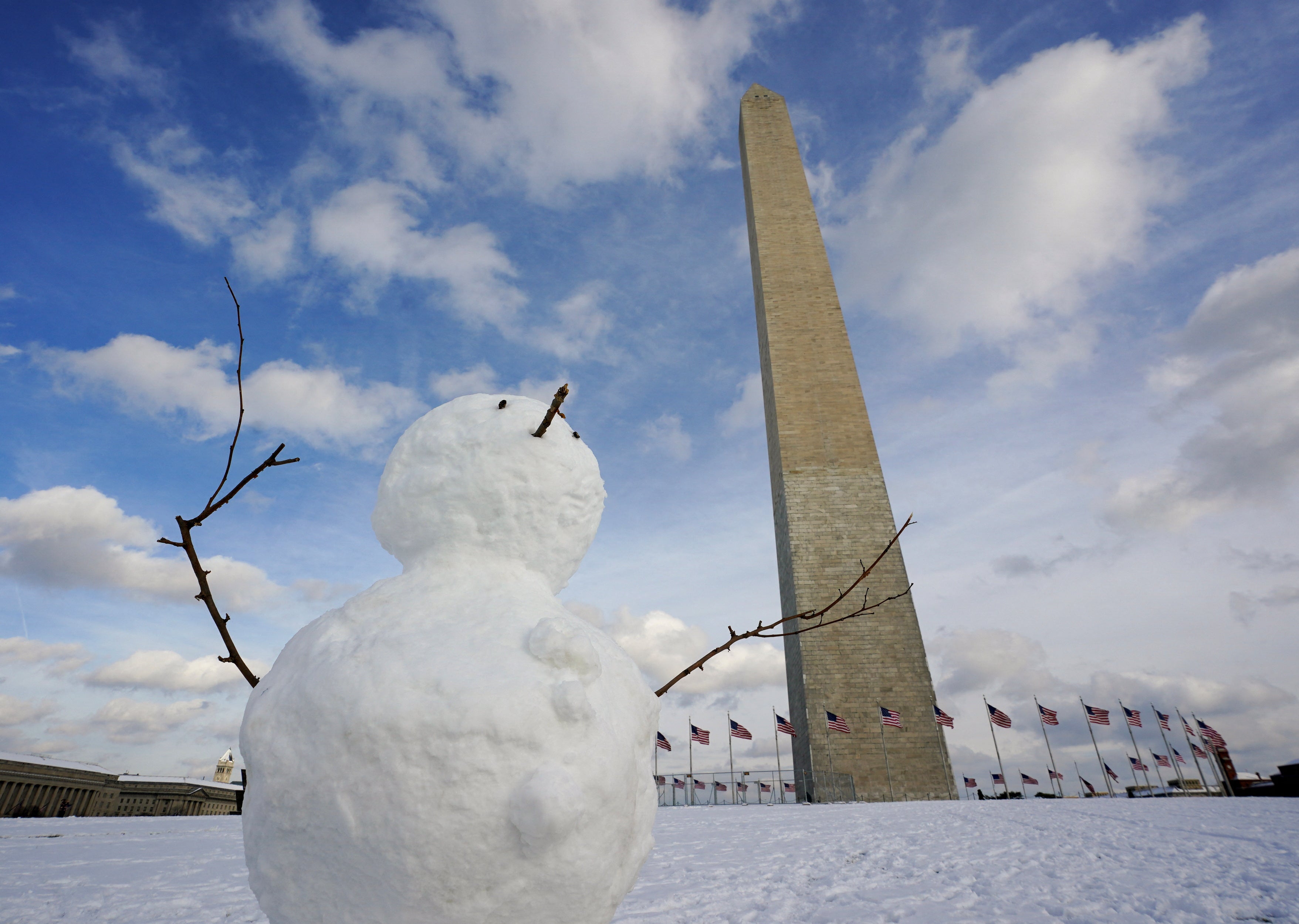 A snowman is built in front of the Washington Monument on the National Mall after a snowfall in Washington