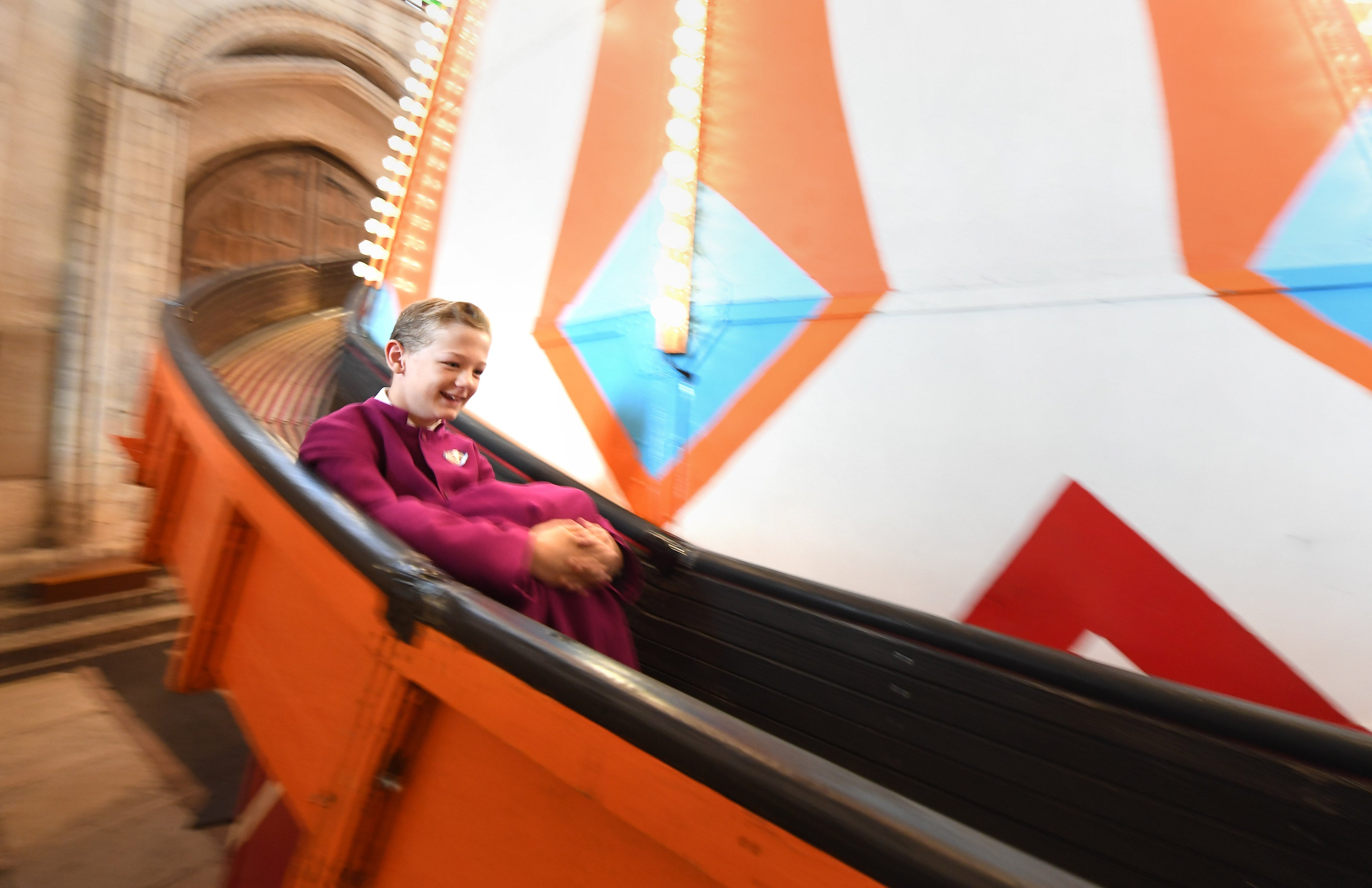 A chorister goes down a 40ft helter skelter installed inside Norwich Cathedral