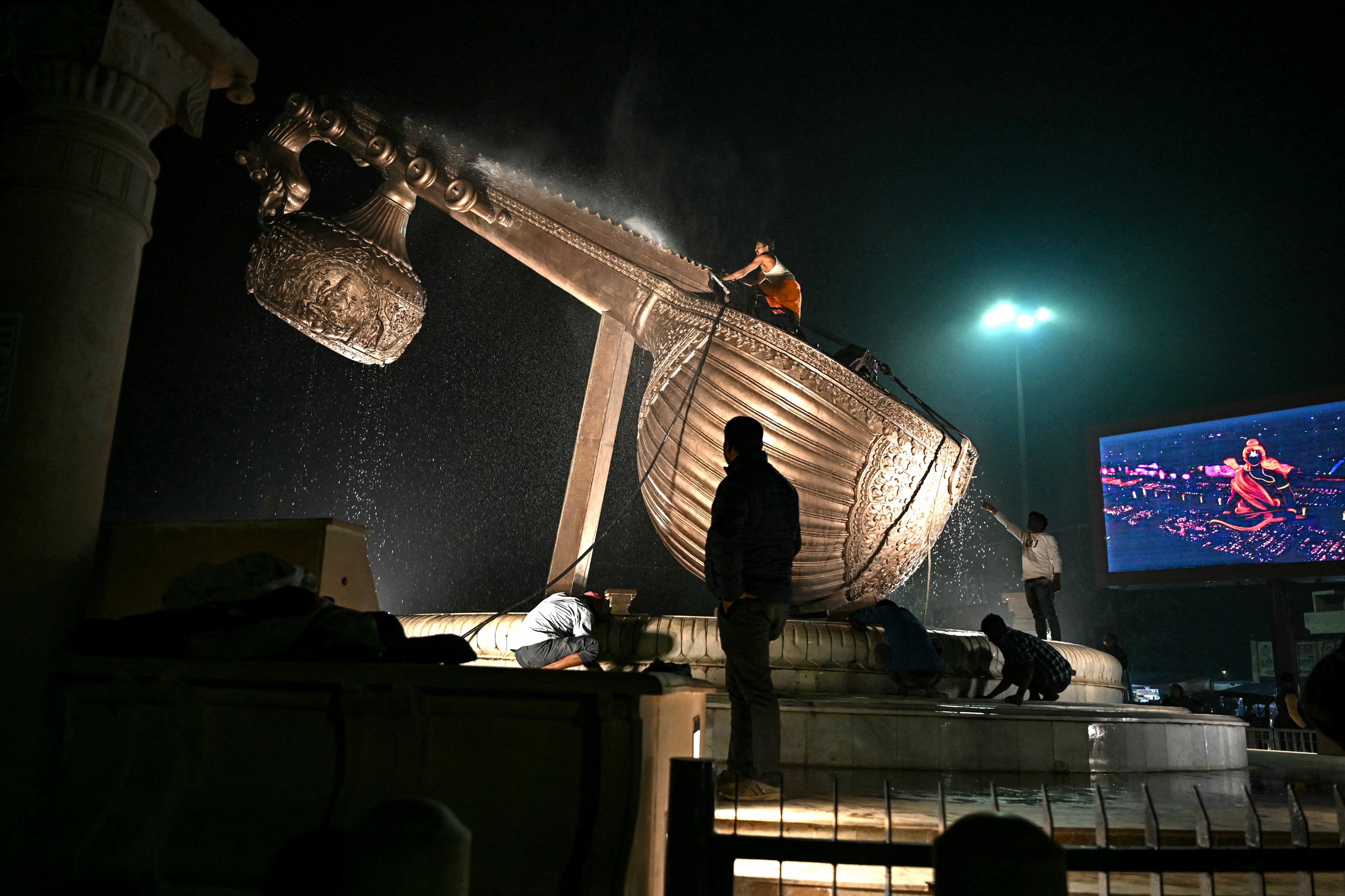 Workers clean a sculpture of a Hindu classical music instrument in Ayodhya