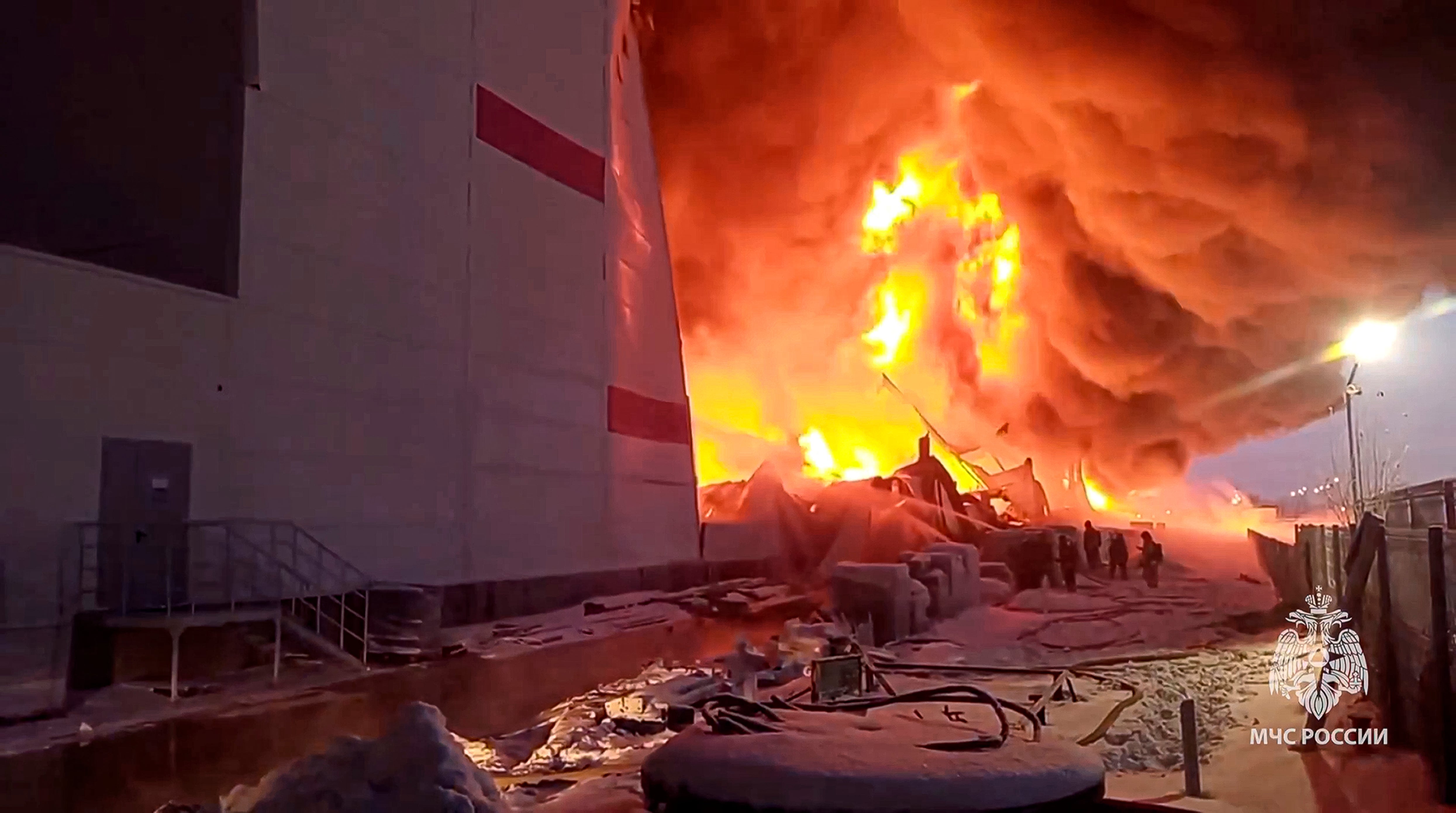 Russian Emergency Situations Ministry firefighters work at the side of the warehouse in St Petersburg, Russia