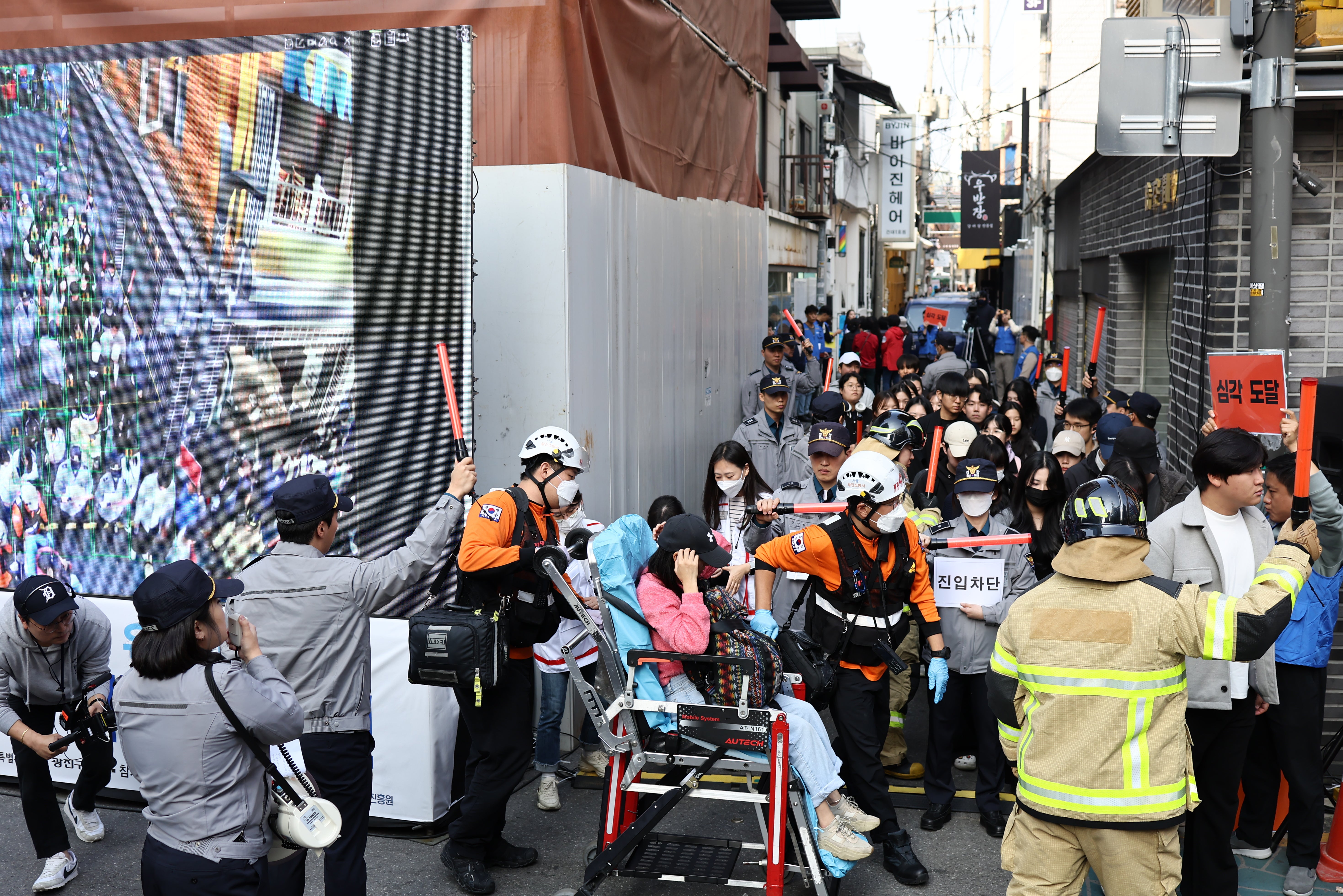 People take part in a drill, conducted by the police, on a street in Seoul, 25 October 2023