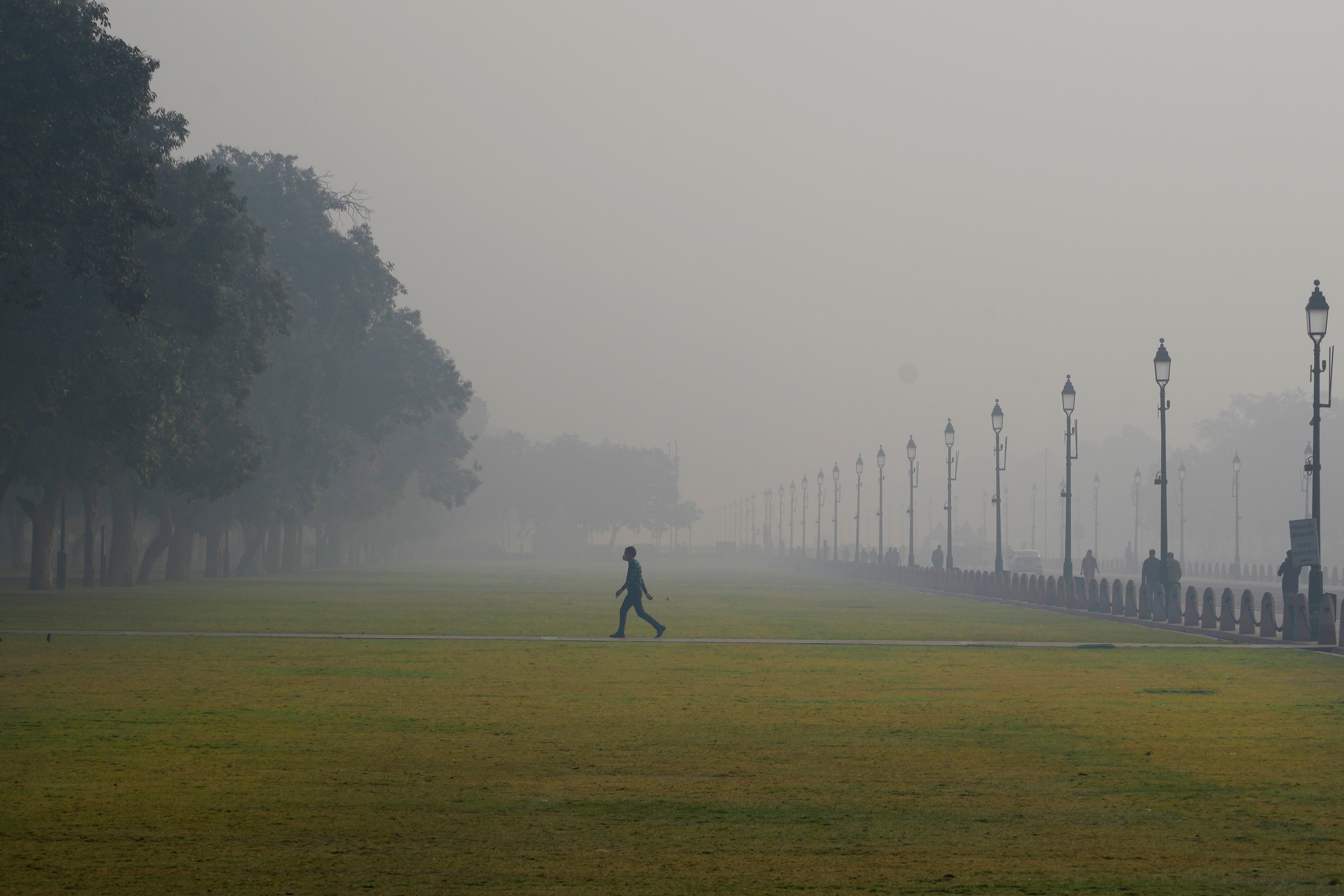 A man walks, enveloped by smog early morning in New Delhi, India, 13 Dec 2023