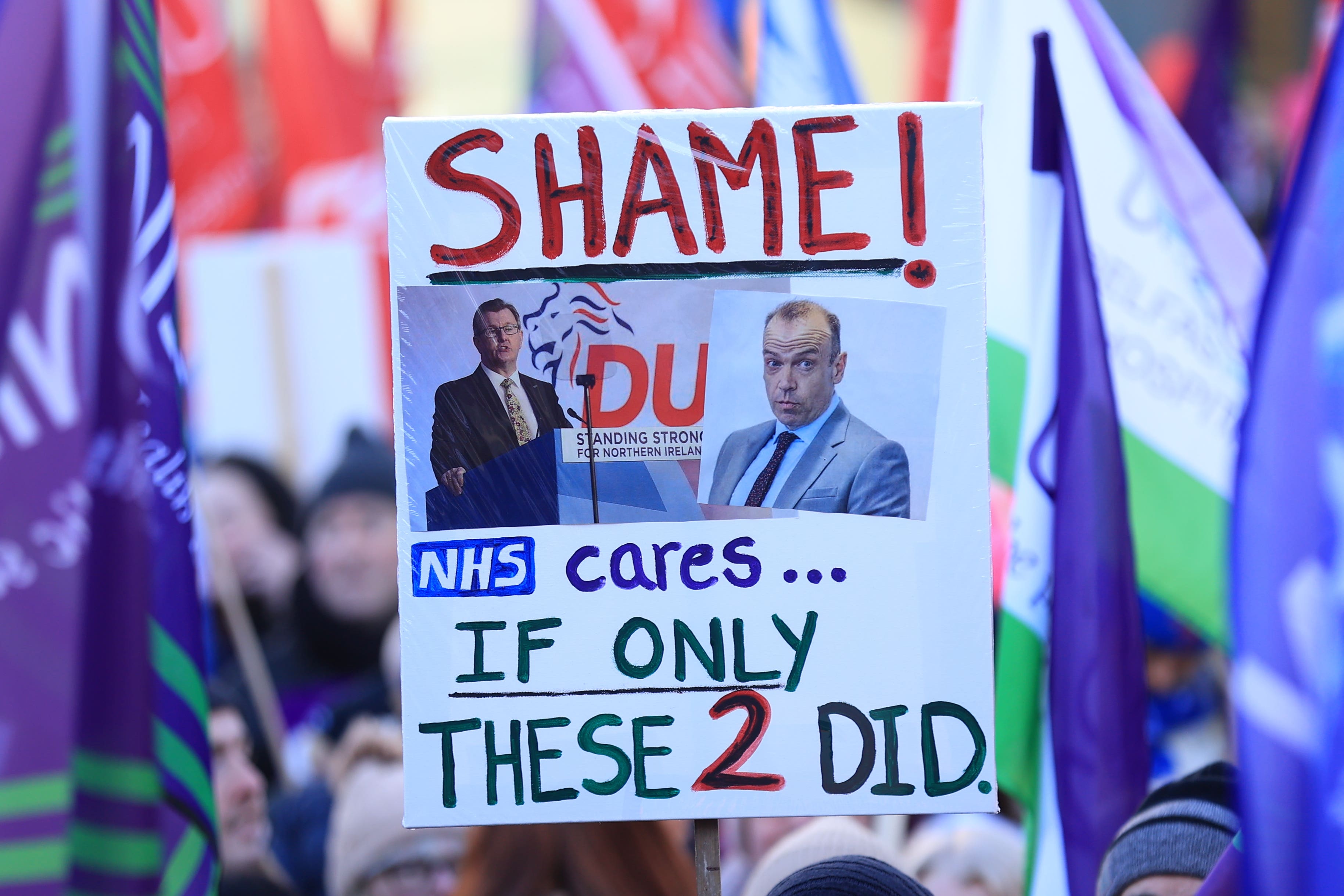 A sign at the public sector workers rally at Belfast City Hall (PA)