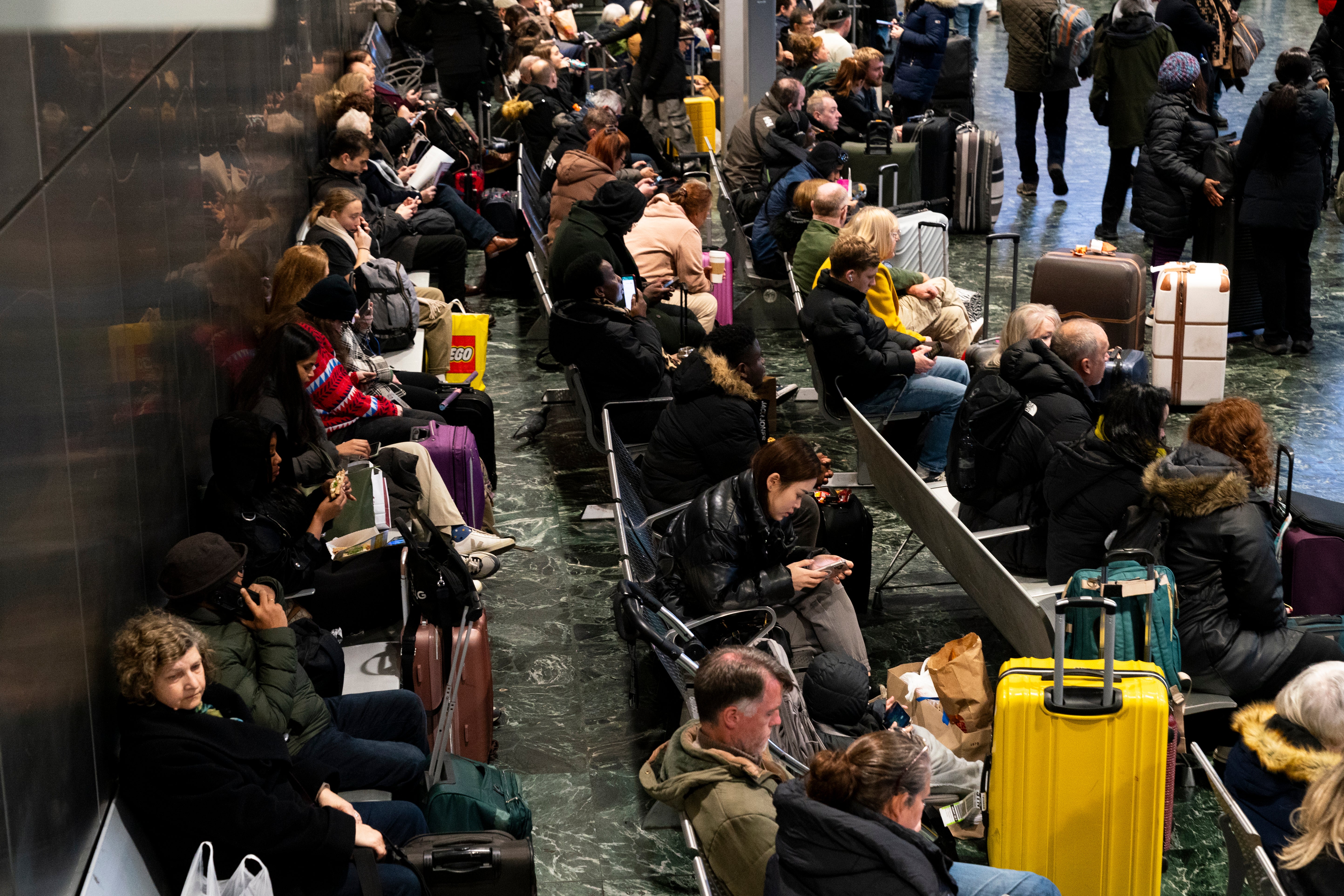 Passengers at Euston station, London, following train delays as Storm Isha has brought severe disruption to rail services.