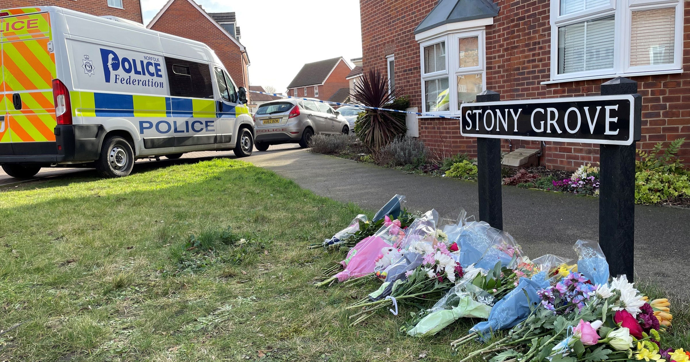 Floral tributes left near a house in Costessey near Norwich after four people were found dead inside the property