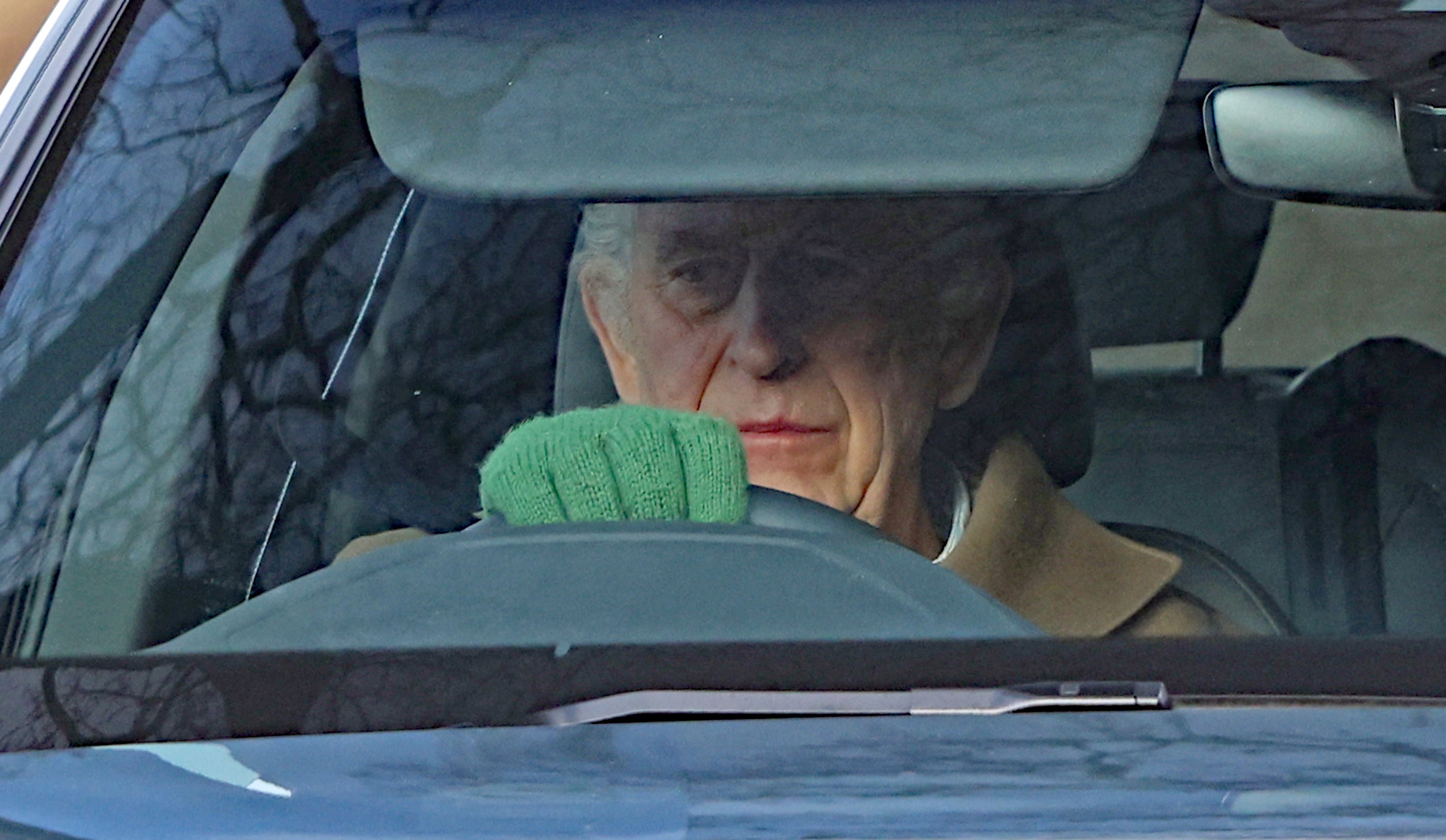 King is pictured driving around his Sandringham Estate