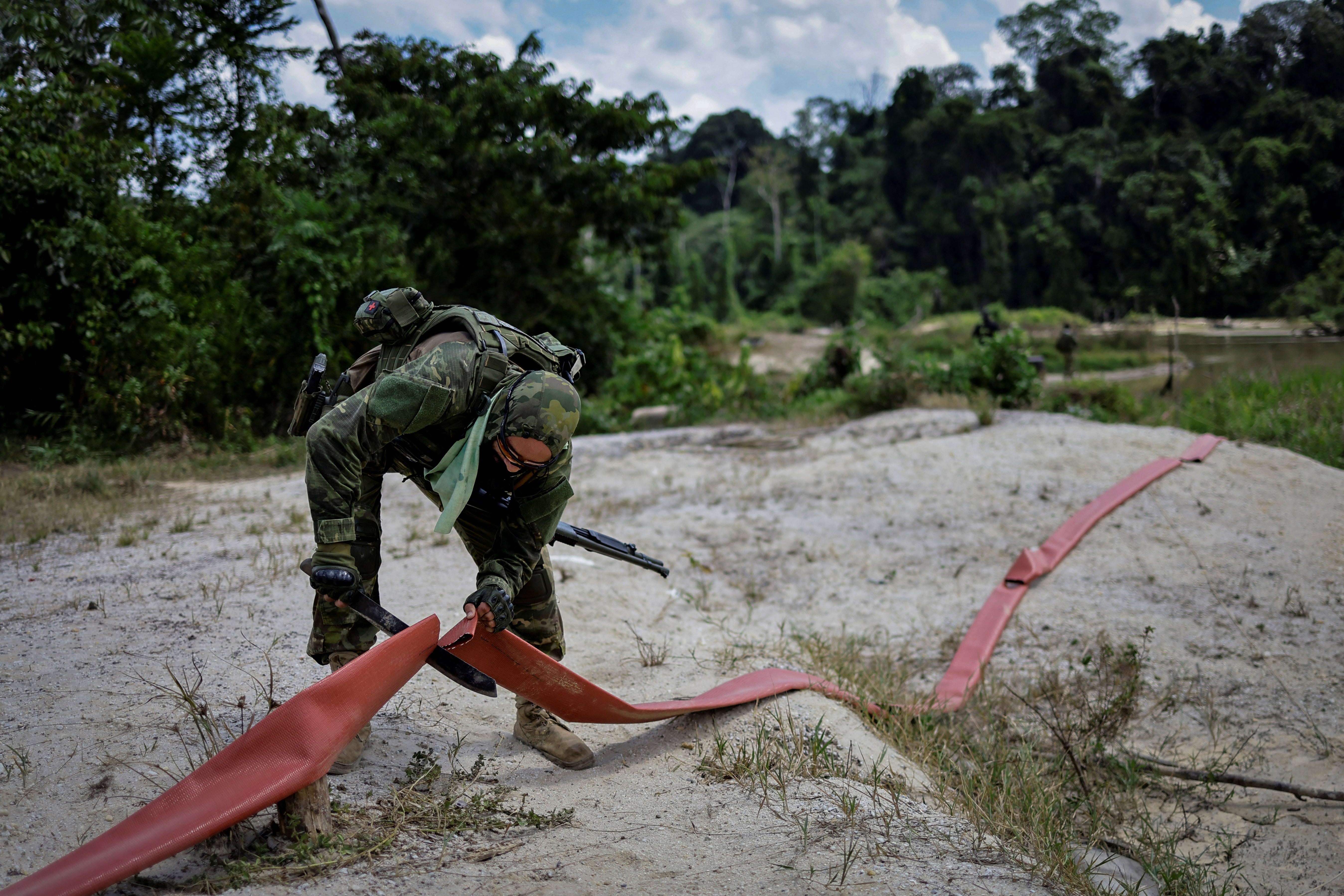 A member of the Special Inspection Group from Ibama destroys equipment used for dredging during an operation against illegal mining