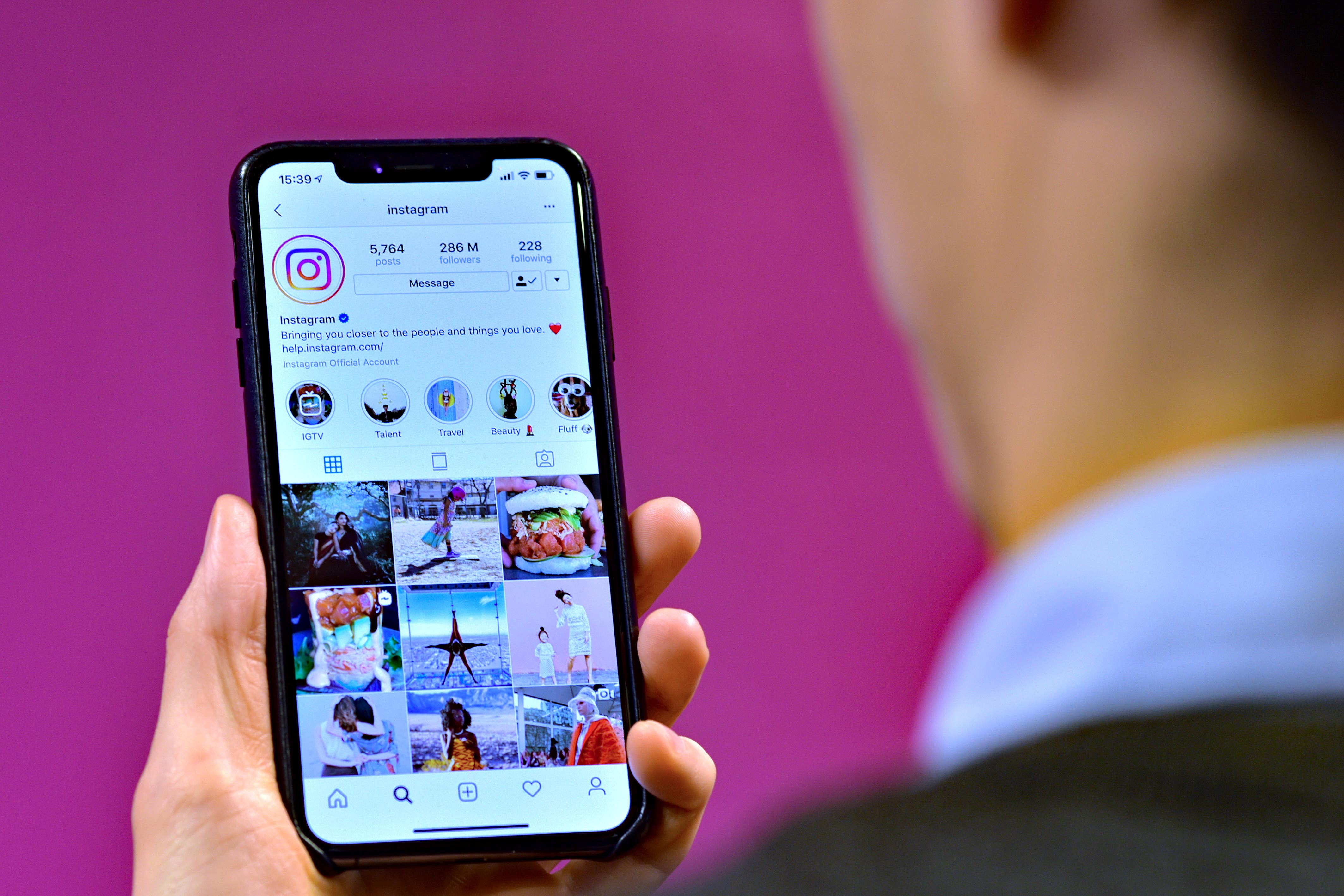 Stock photo of a man looking at the home page of social media site Instagram on a smartphone.