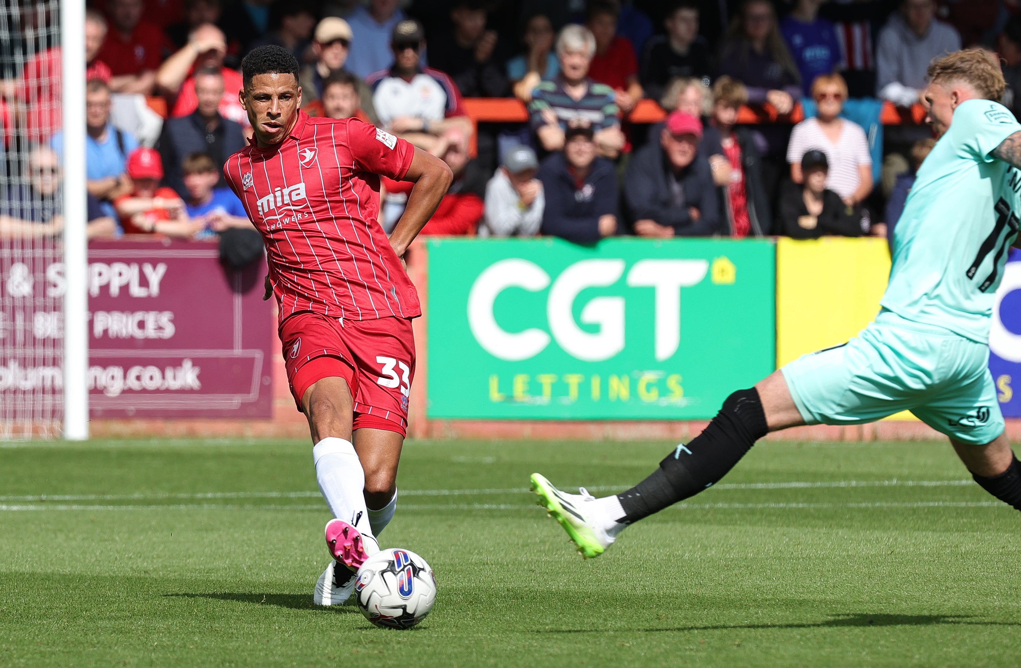 Curtis Davies of Cheltenham Town plays the ball