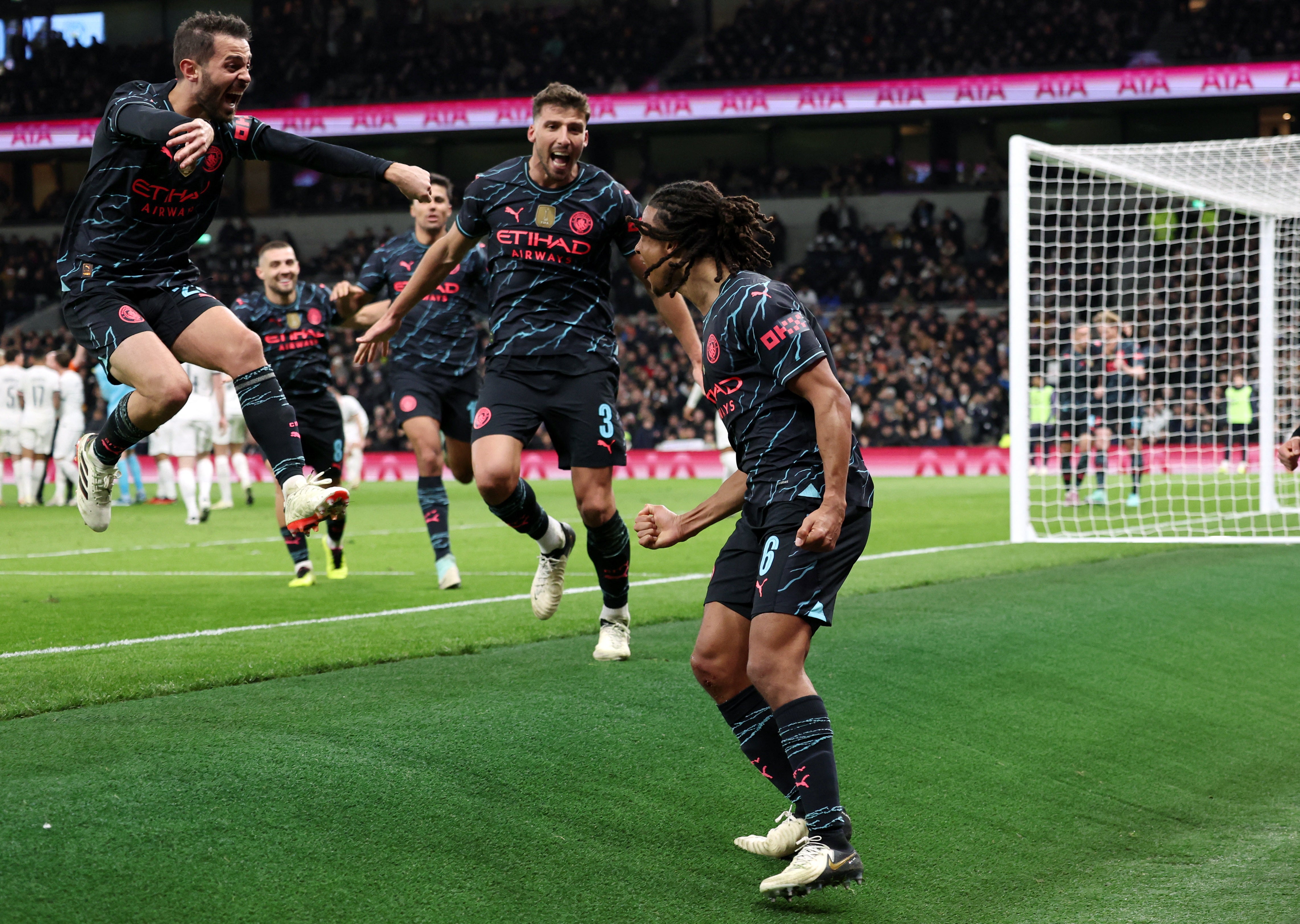 Manchester City players celebrate after Nathan Ake, right, scores their winning goal