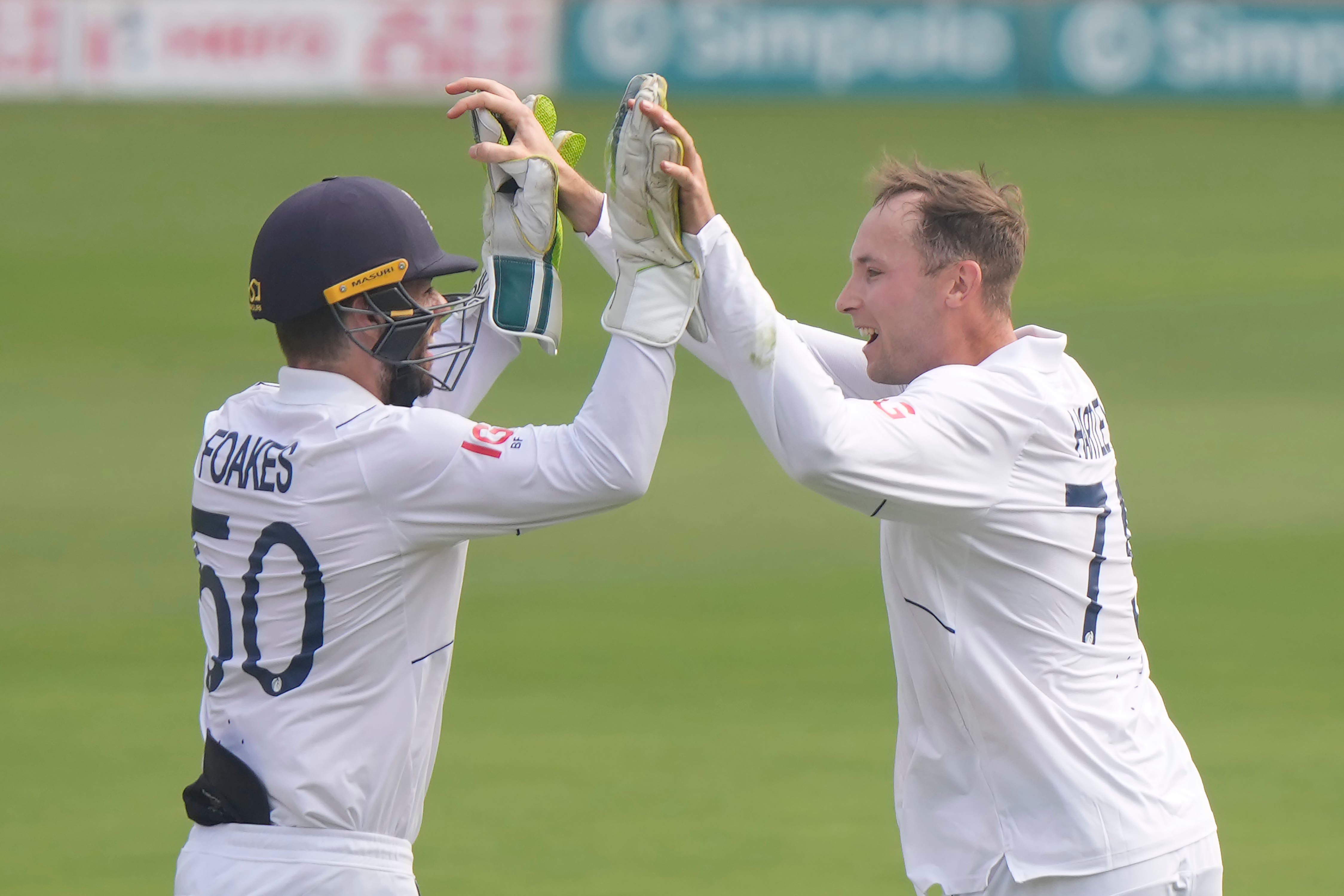 England’s Tom Hartley, right, celebrates with wicketkeeper Ben Foakes (Manesh Kumar A/AP)