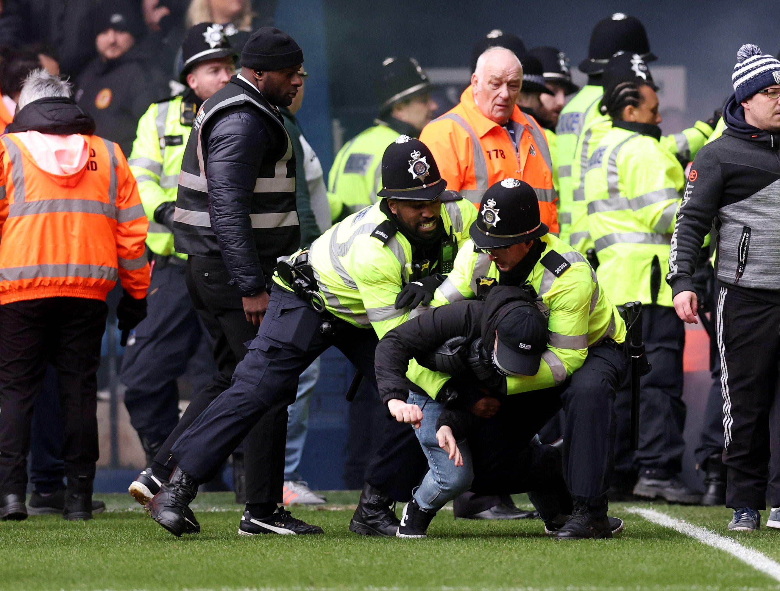 A man is wrestled to the floor by police officers