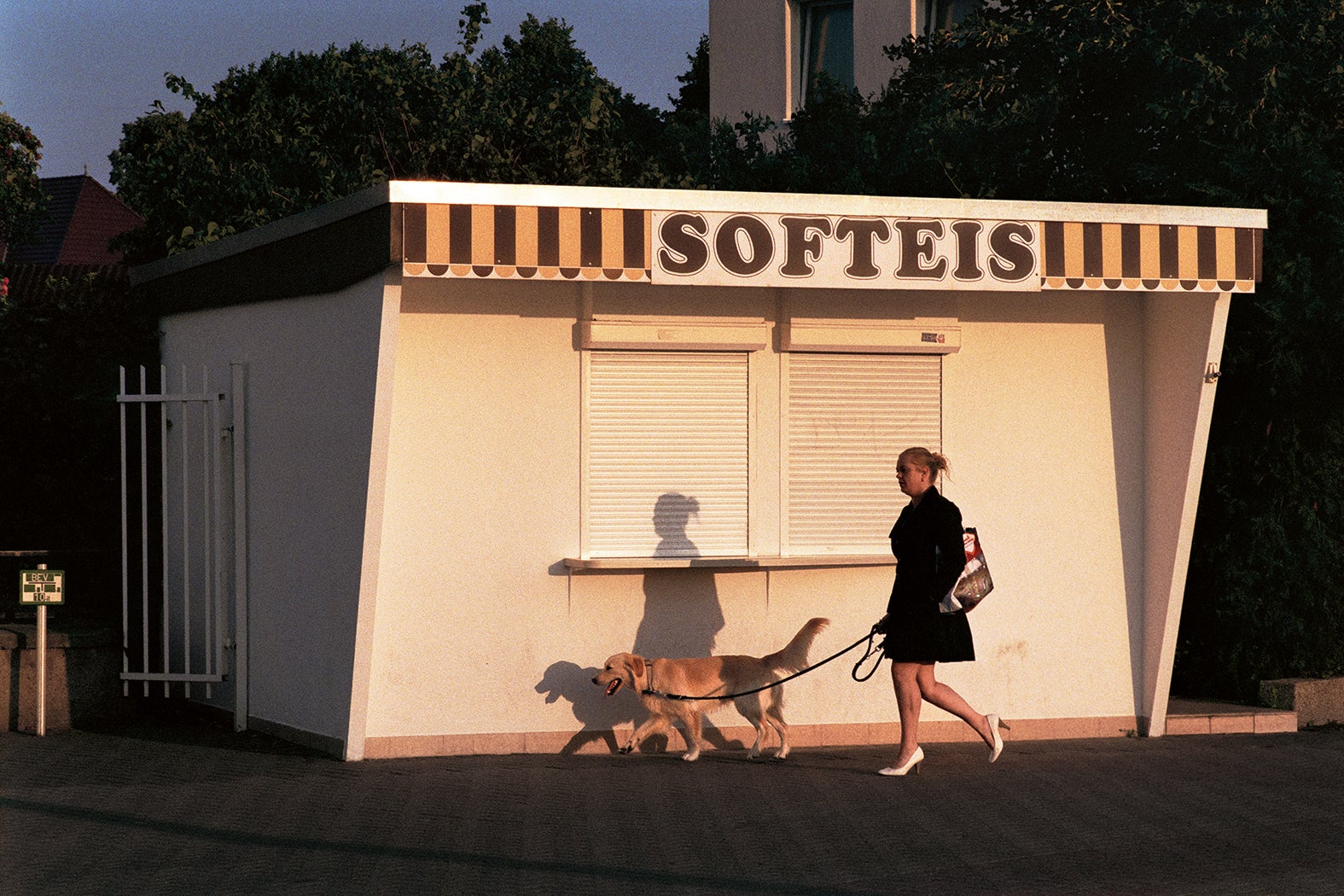 Early in the morning, a woman walks her dog in the still deserted tourist district of a coastal town in Warnemunde