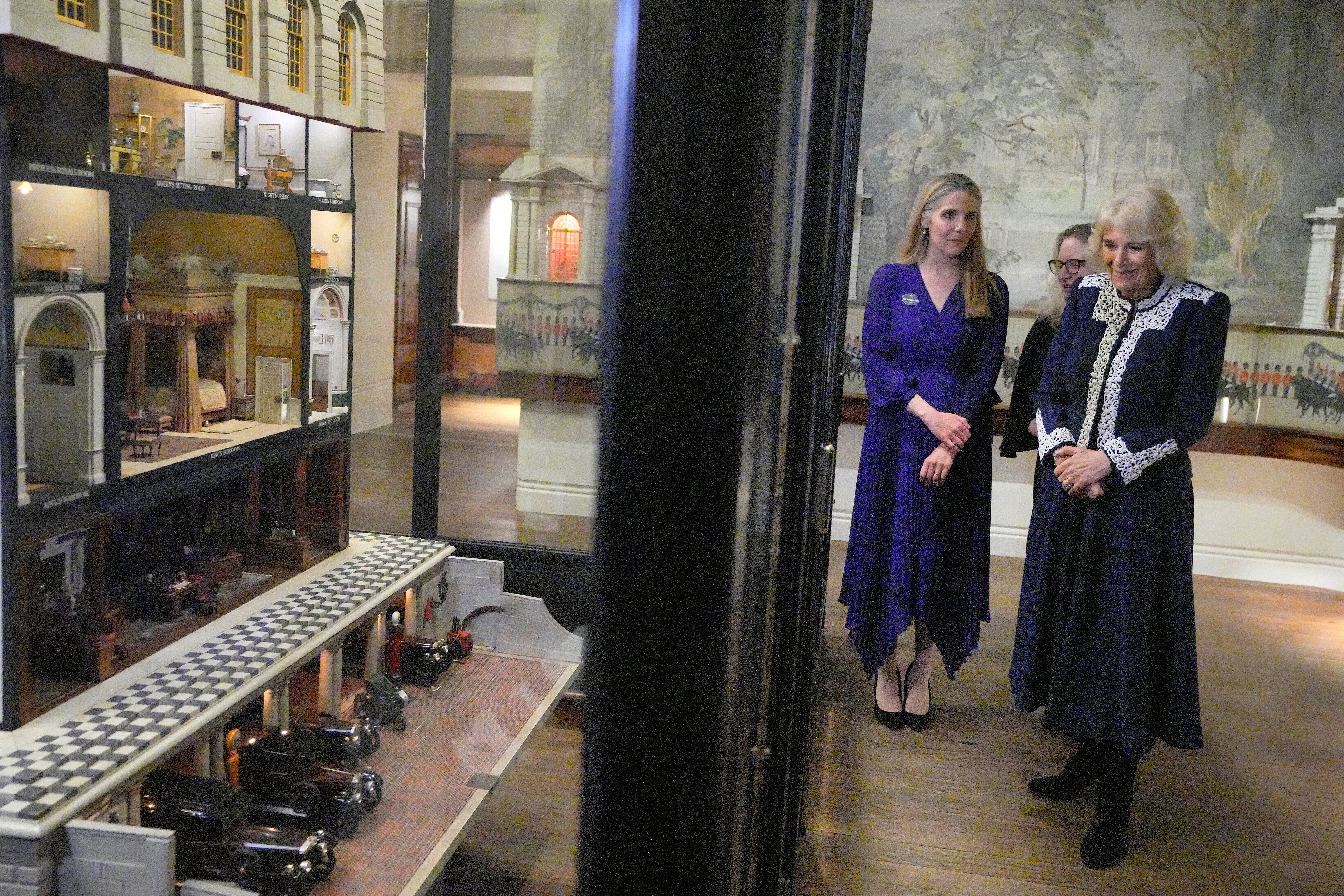 Britain's Queen Camilla looks at Queen Mary's Dolls' House as she hosts a reception at Windsor Castle for authors, illustrators and binders