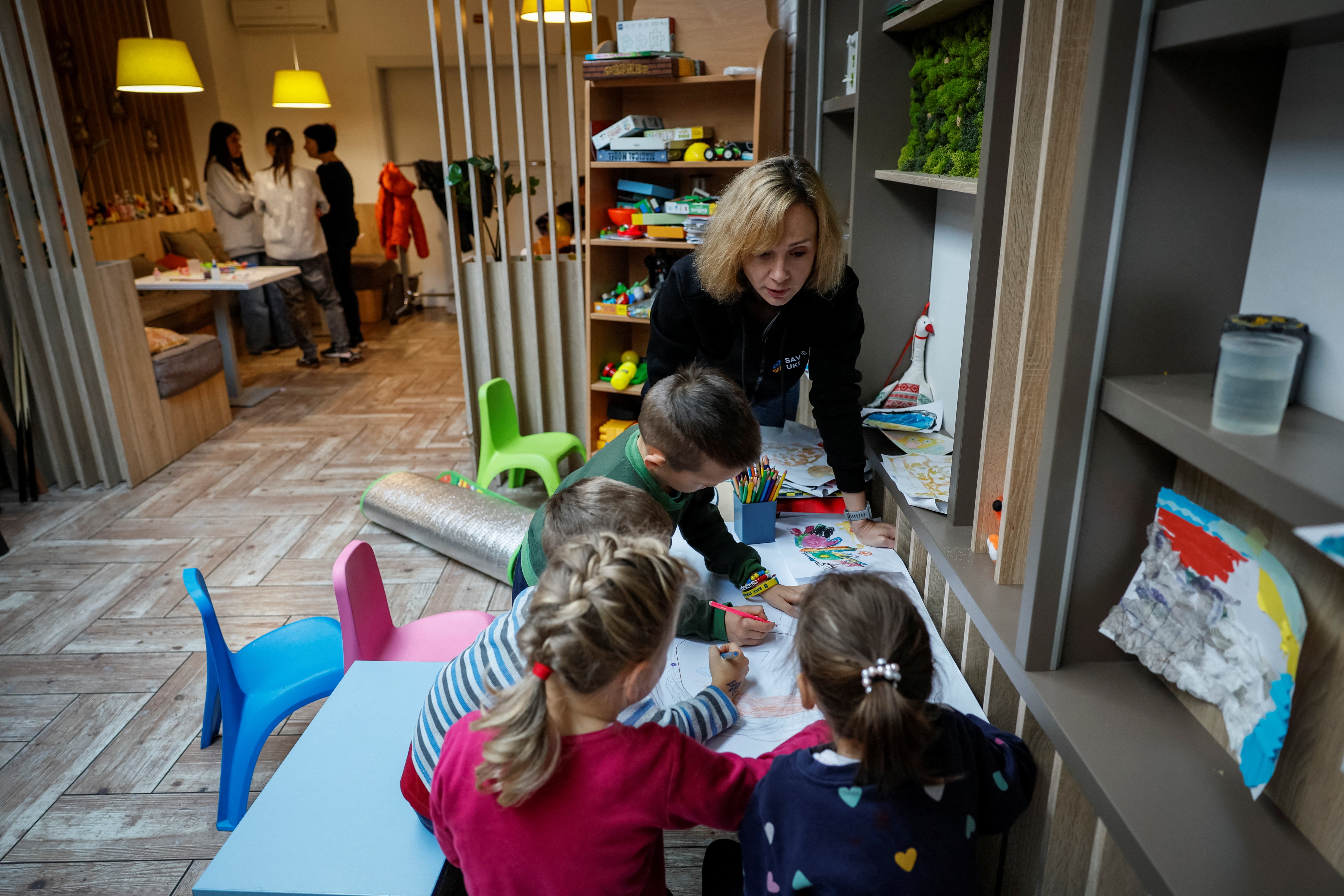 A volunteer of Save Ukraine paints with rescued children, in Kyiv, Ukraine