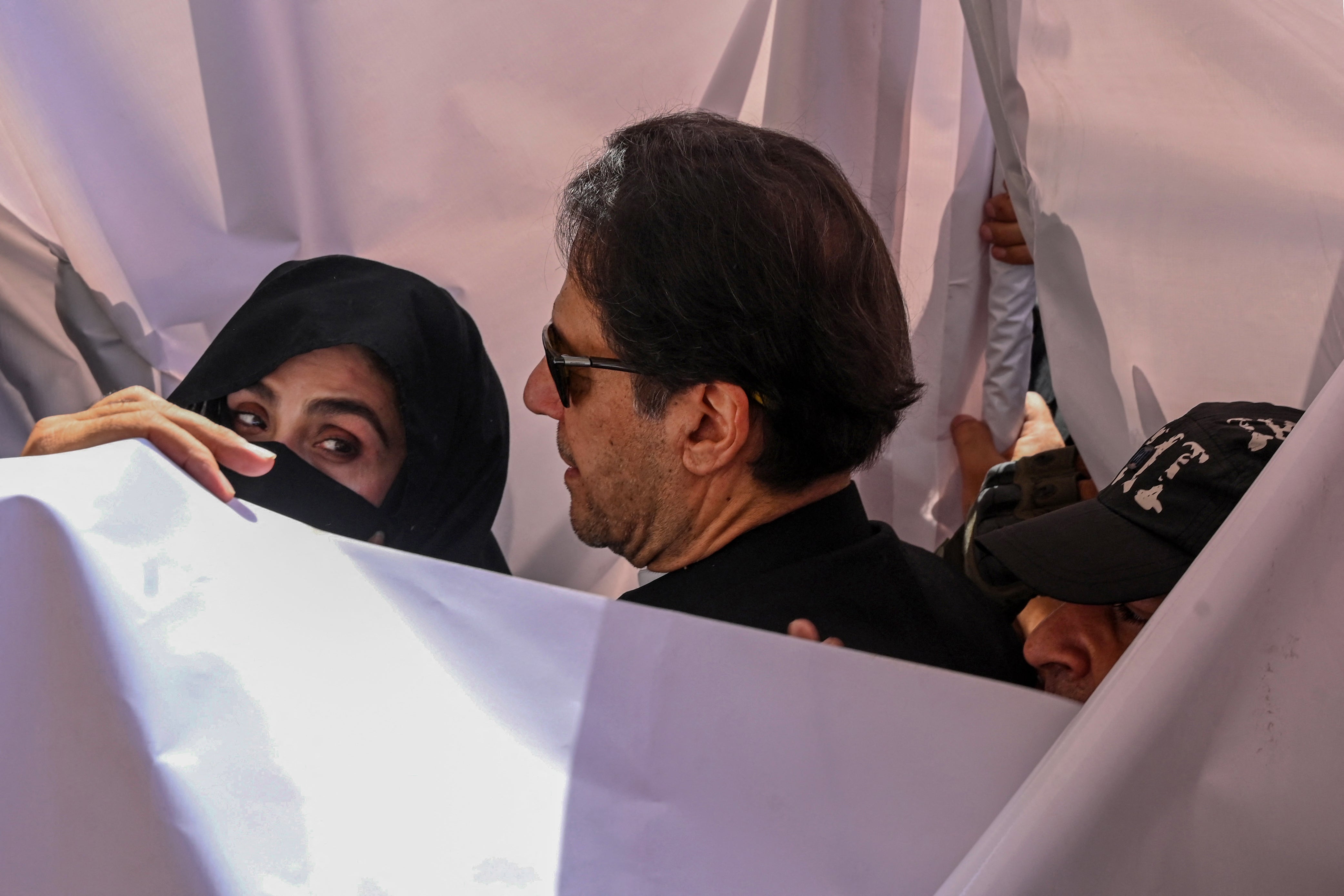 Former Pakistan Prime Minister Imran Khan (C) with his wife Bushra Bibi (L) arrive to appear at a high court in Lahore in May 2023