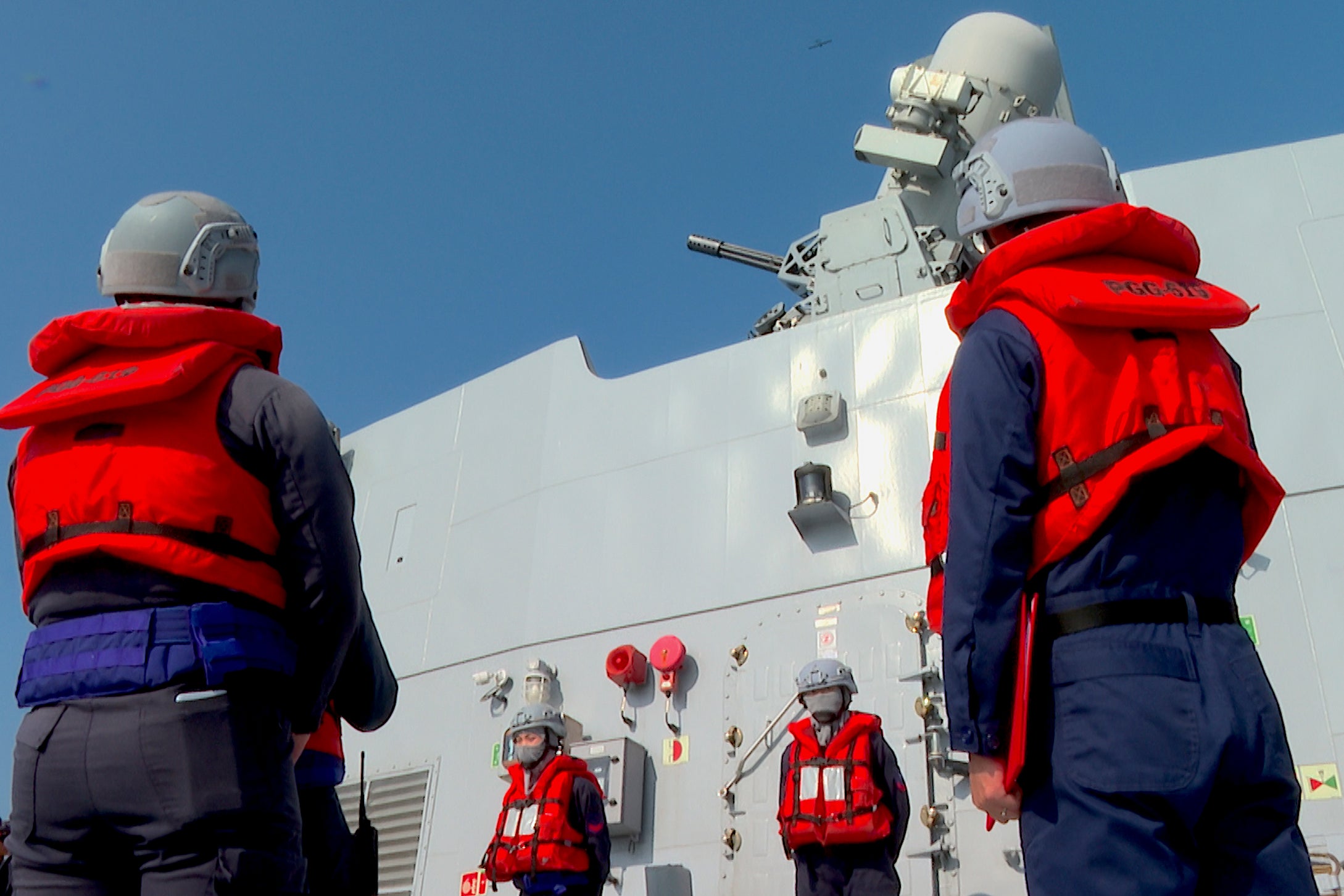 Taiwanese sailors on board a corvette stand near the Phalanx close-in weapon system