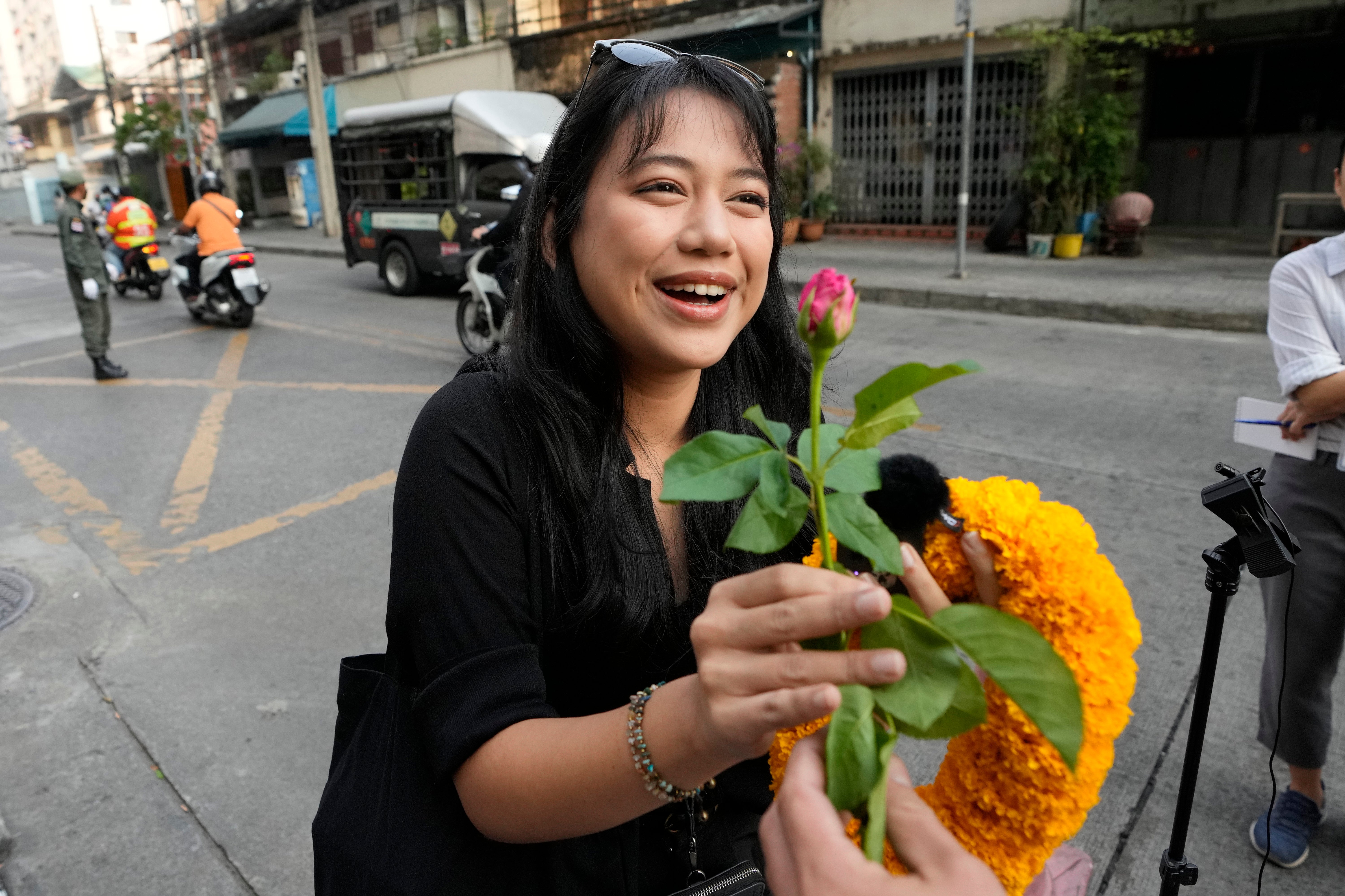 Patsaravalee Tanakitvibulpon receives a garland from her supporter on her arrival at Southern Criminal Court in Bangkok