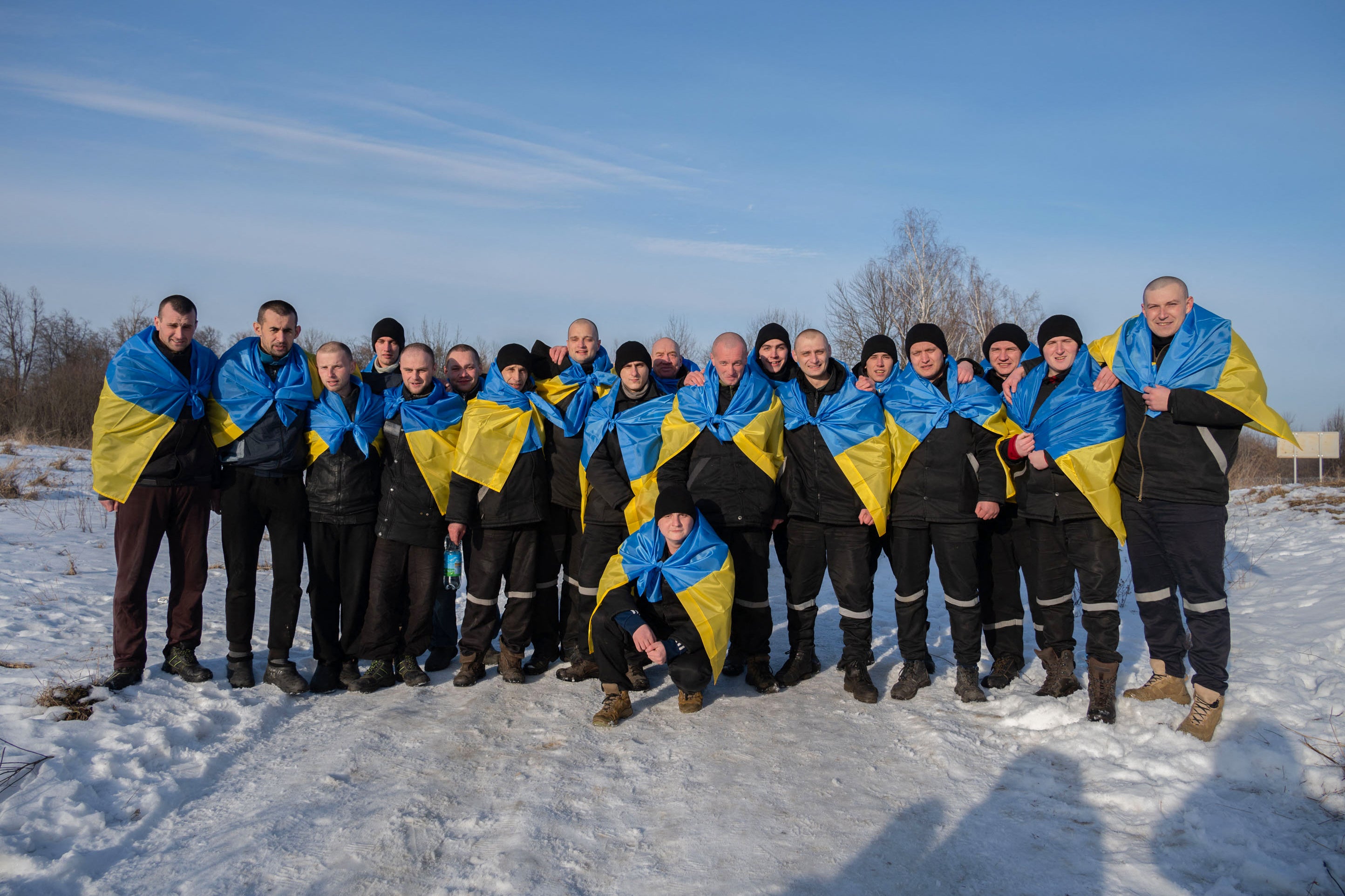 Ukrainian former prisoners of war, wrapped in a Ukrainian flag, posing following a prisoner exchange, amid Russia’s military invasion on Ukraine