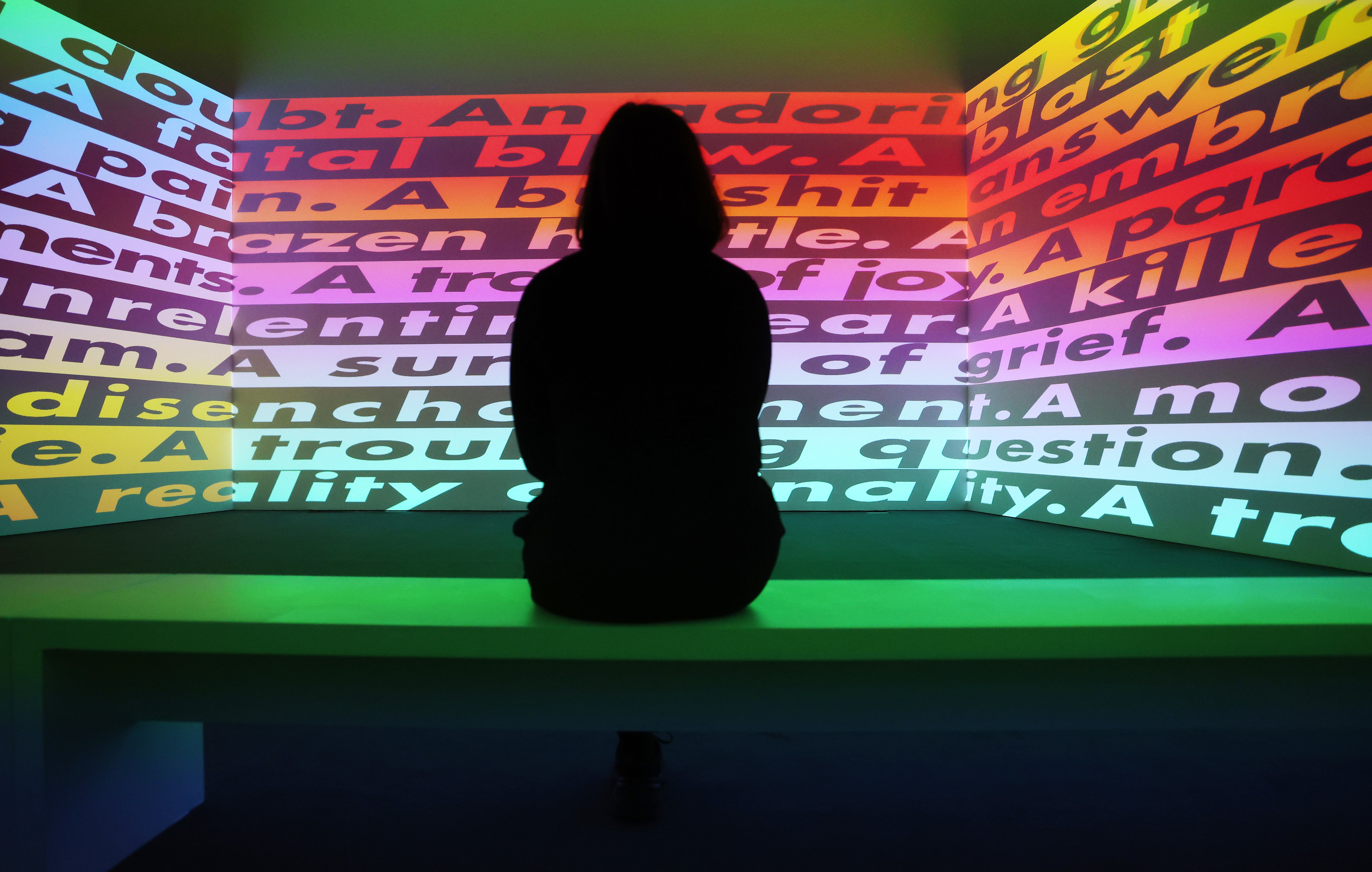 A Serpentine Gallery worker looks at a video work by US artist Barbara Kruger