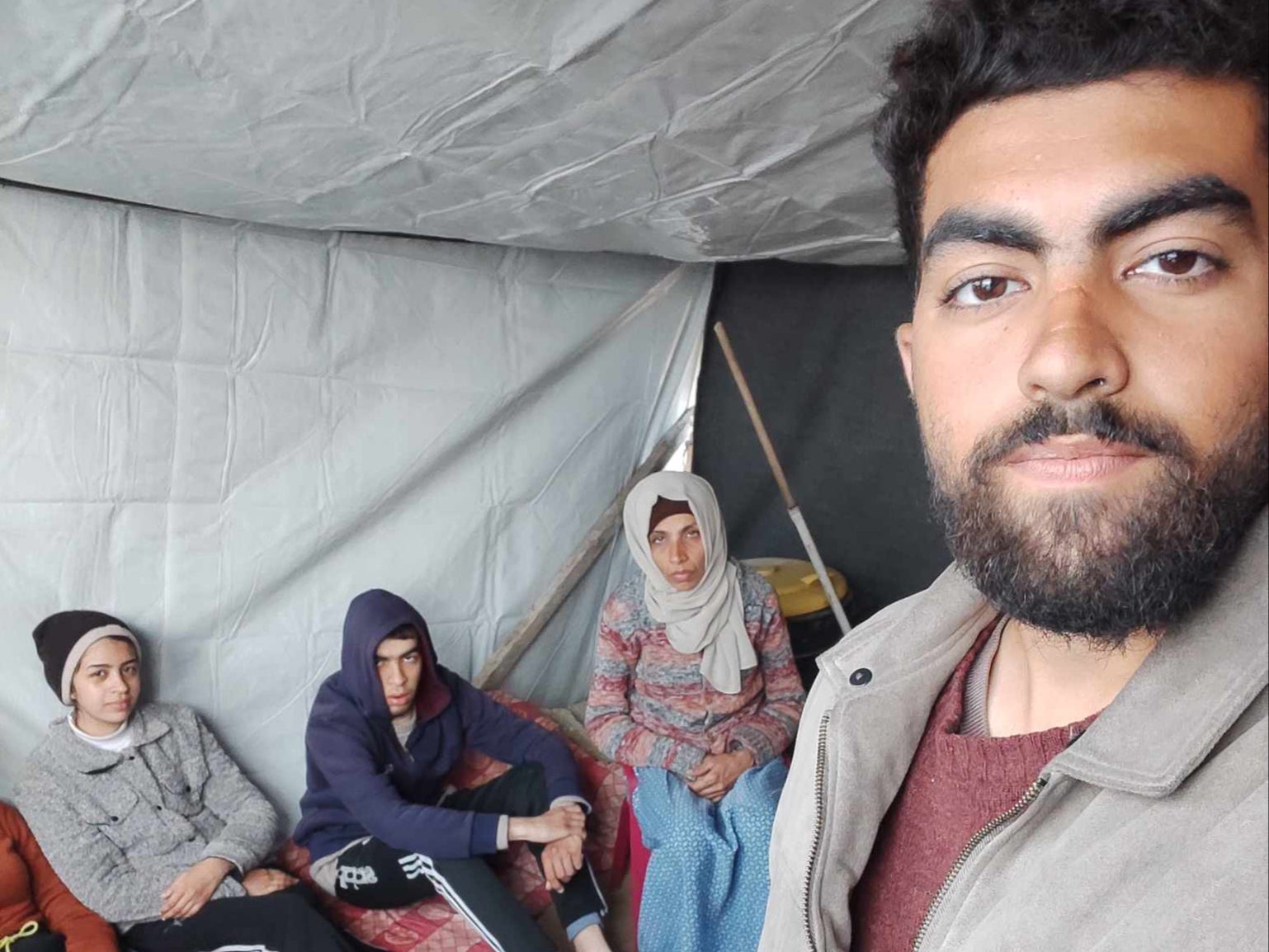 Members of Dr Ghayyda’s family huddle for warmth in a tent