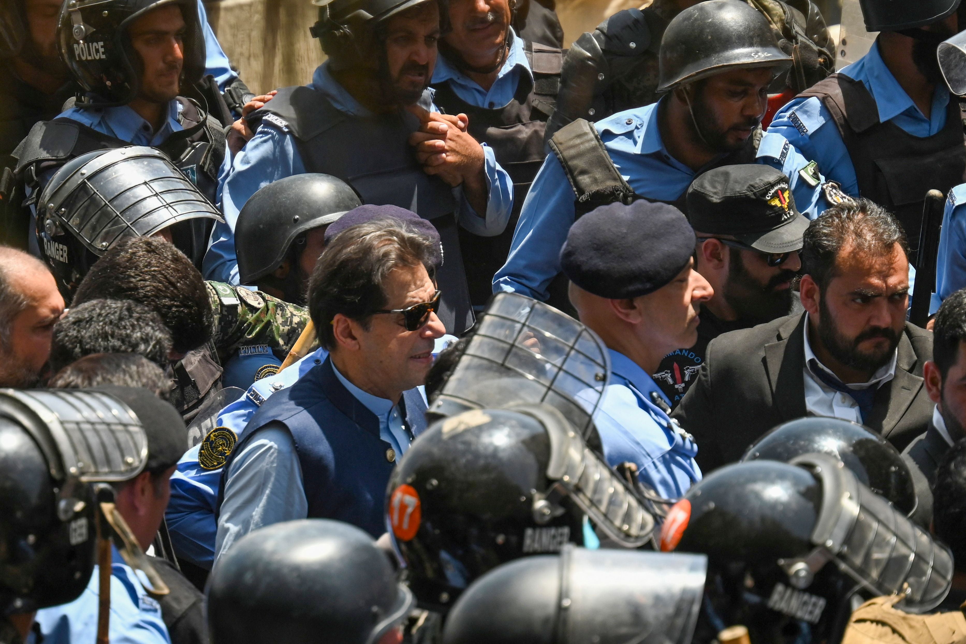 Police escort Khan as he arrives at the high court in Islamabad last May