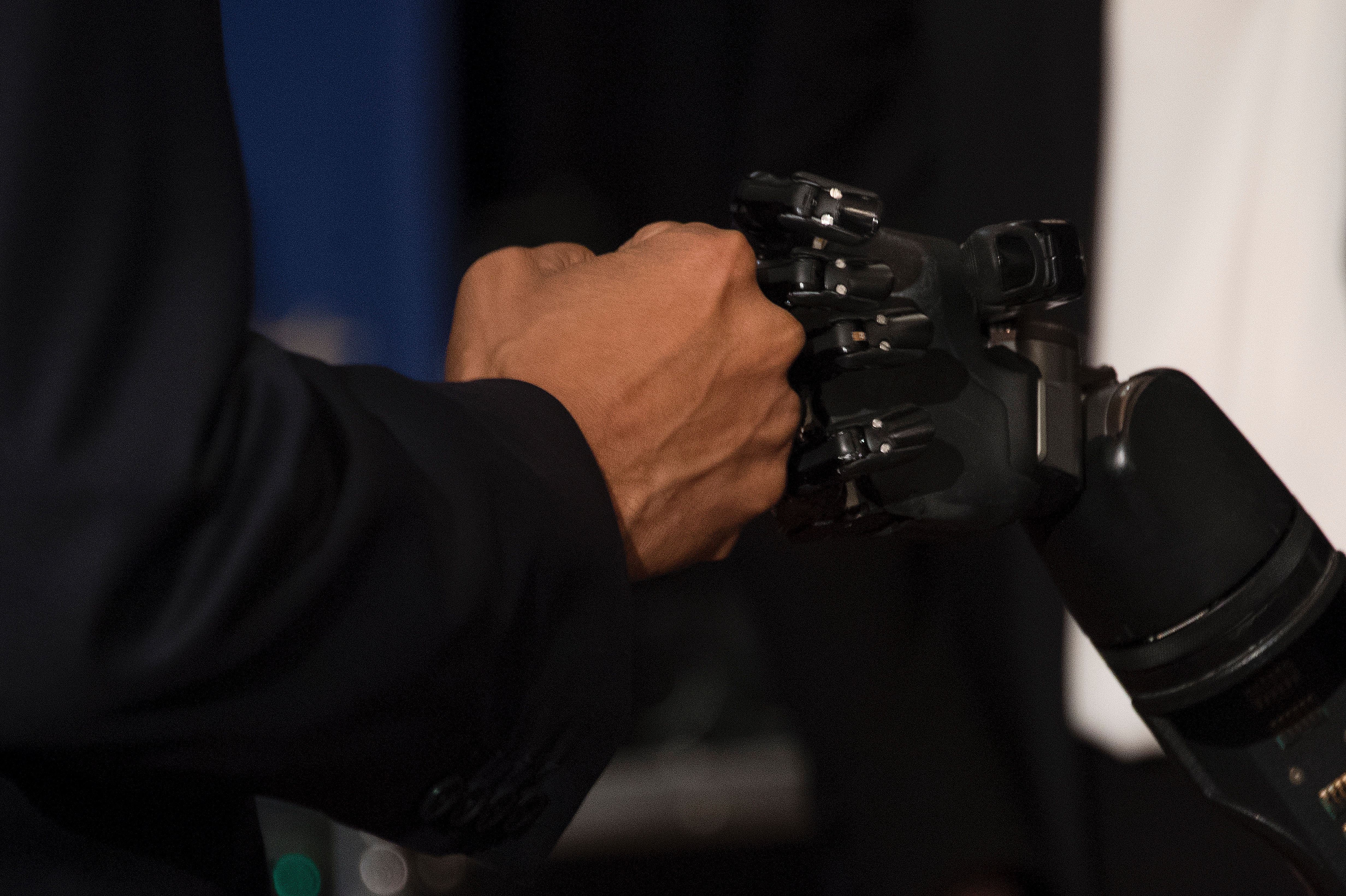 Obama fist bumps the robotic arm of Copeland
