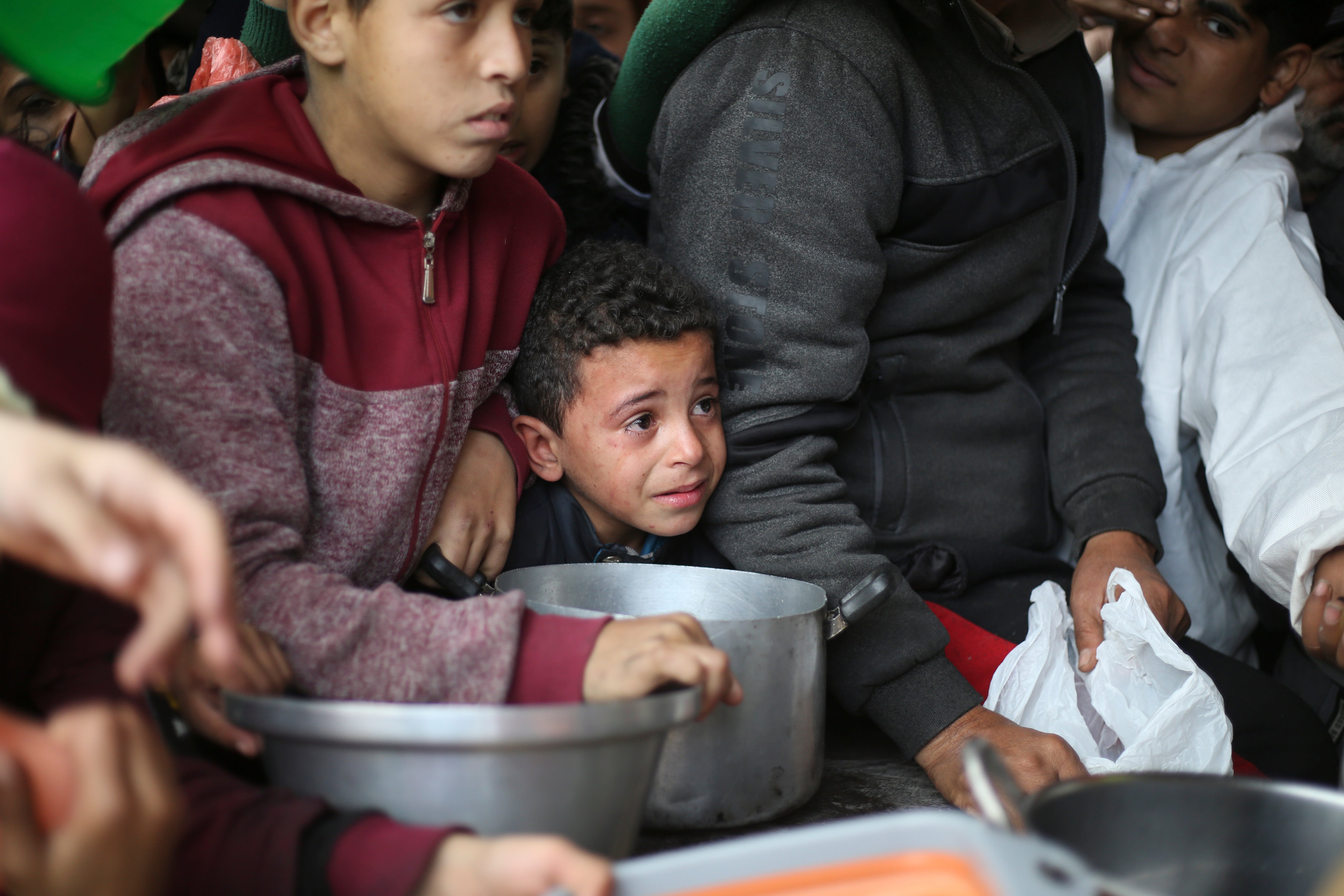 Palestinians line up for free food distribution during the ongoing Israeli air and ground offensive in Khan Younis, Gaza Strip, Friday, Feb. 2, 2024.