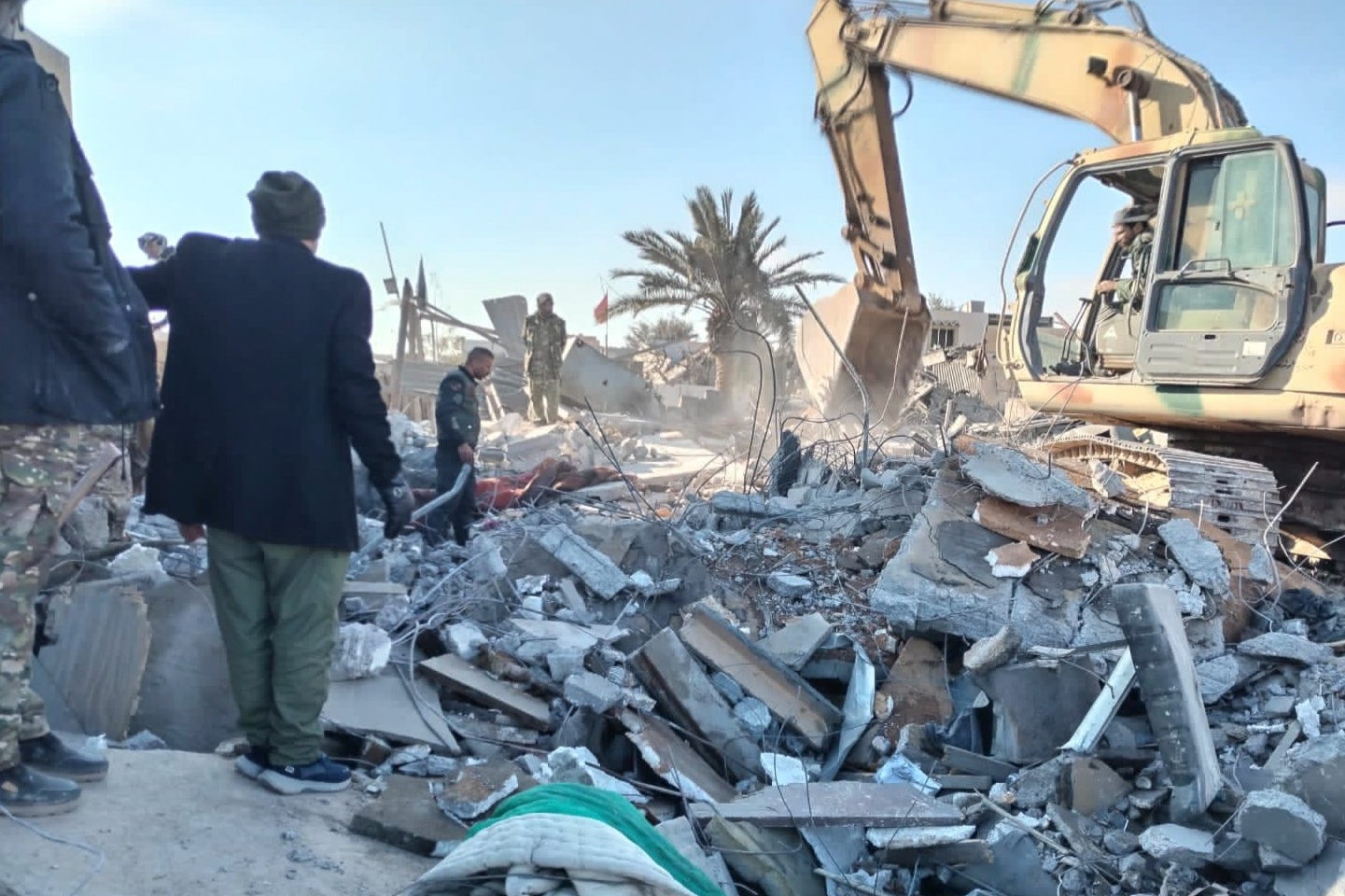 Members of Iraqi Shiite Popular Mobilization Forces clean the rubble after a US airstrike in al-Qaim on February 3 2024