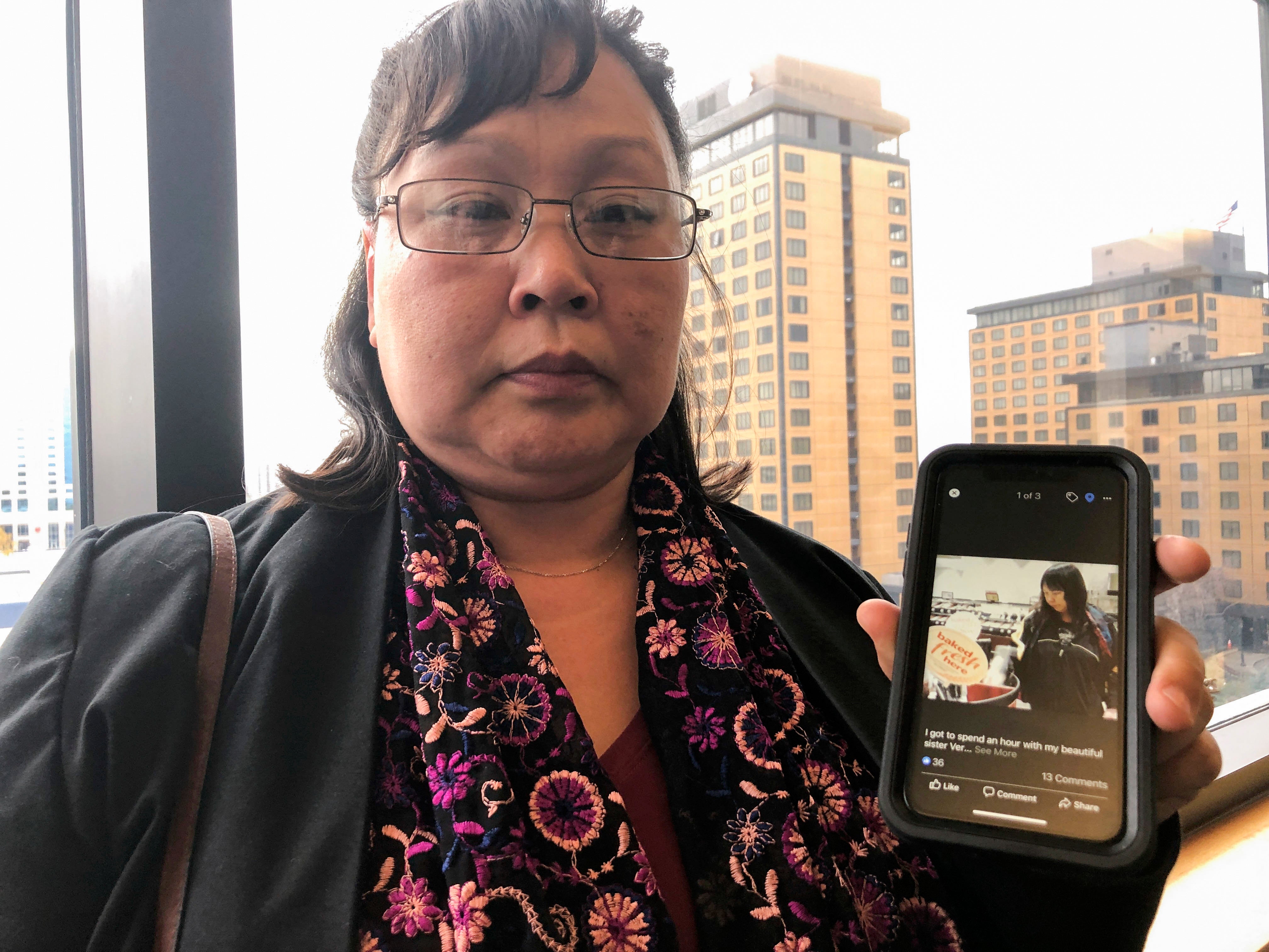 Rena Sapp, outside a courtroom October 21, 2019, in Anchorage, Alaska, shows a photo of her sister, Veronica Abouchuk, taken during a day out shopping in 2013