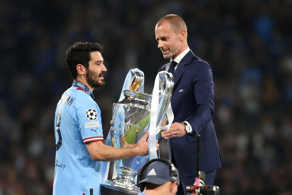 Uefa president Aleksander Ceferin hands over the Champions League trophy