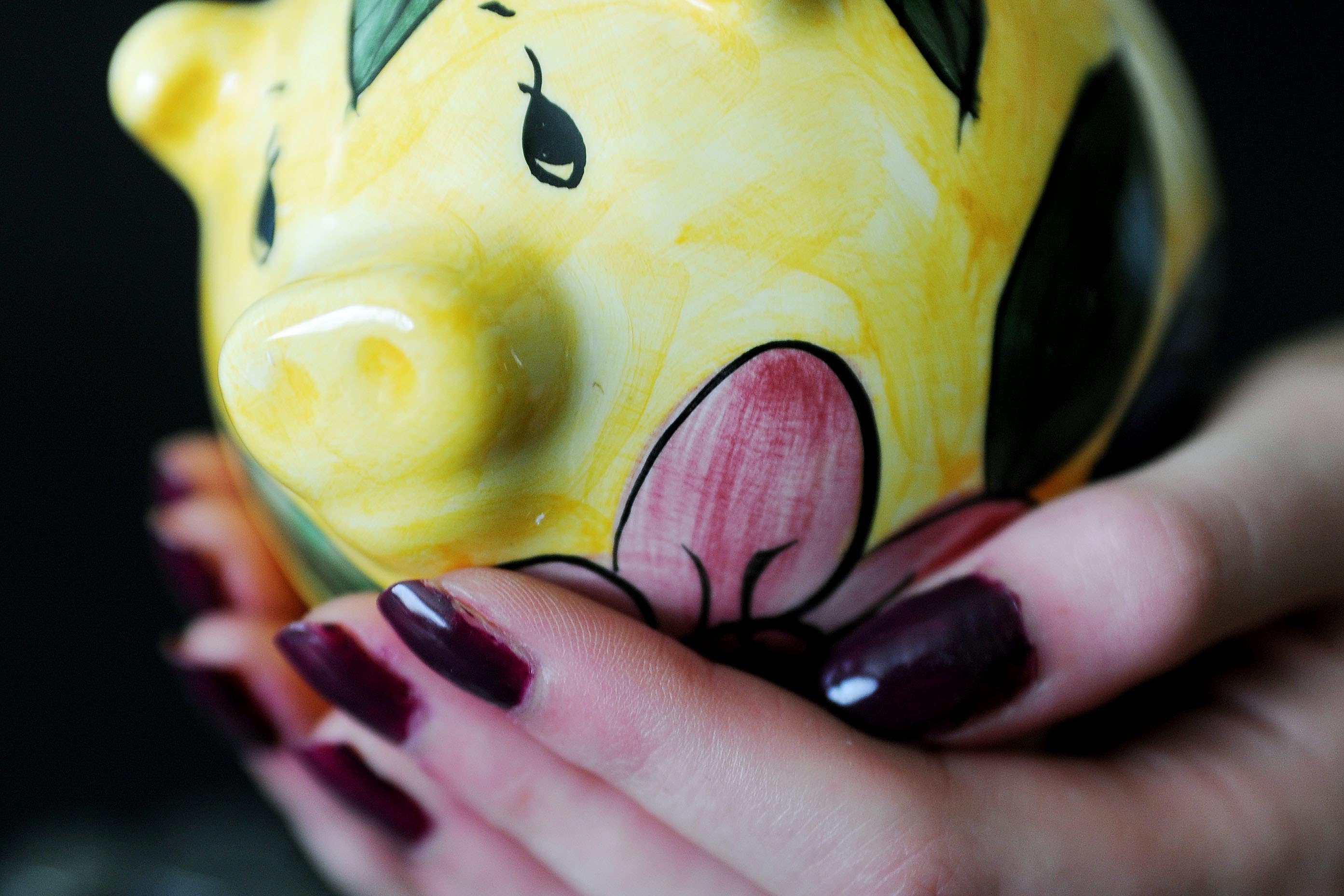 A woman holding a piggy bank