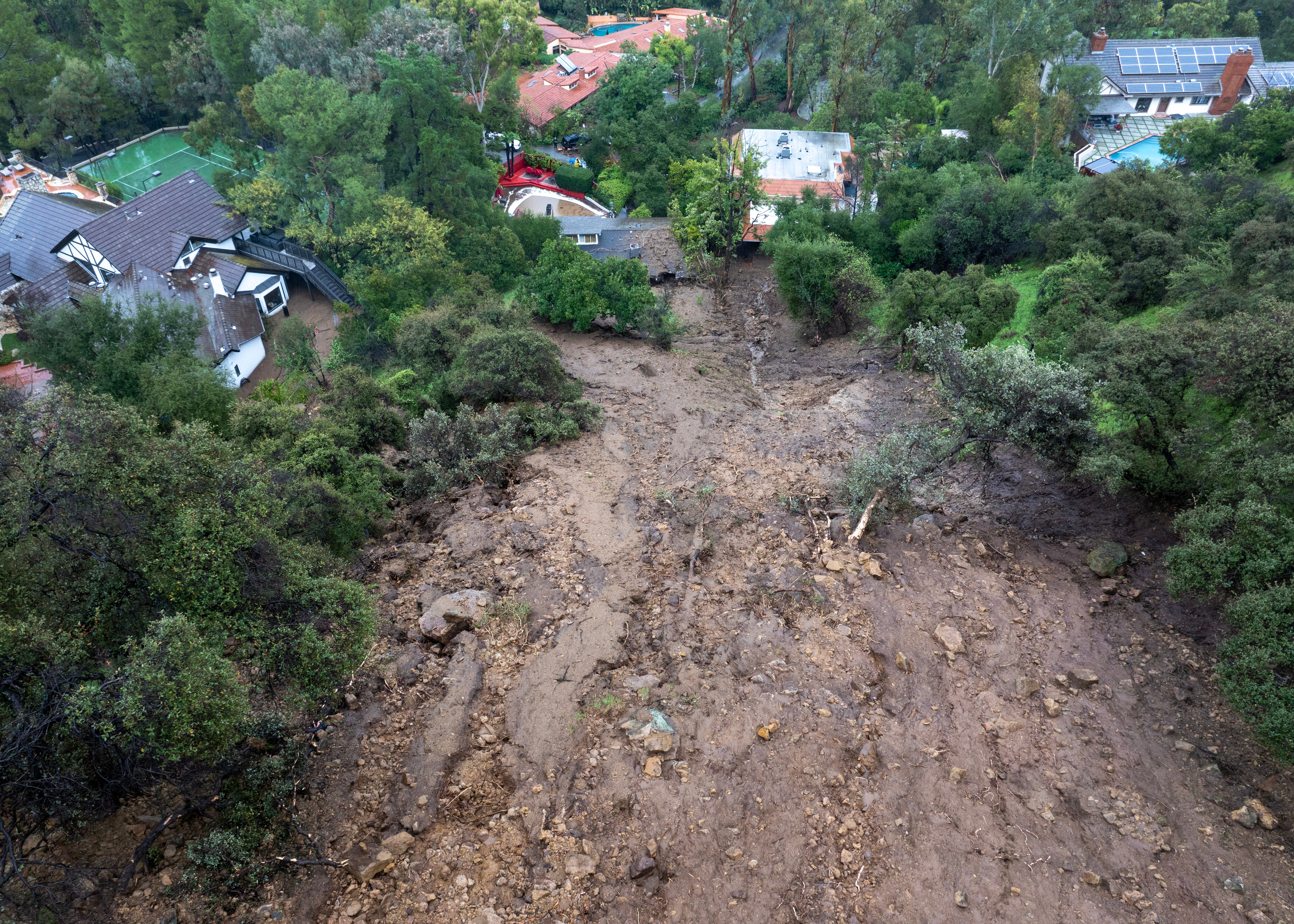 A mudslide from a historic California atmospheric river storm hits a home inLos Angeles, California, last February. Climate change is projected to make these kinds of storms longer and more intense