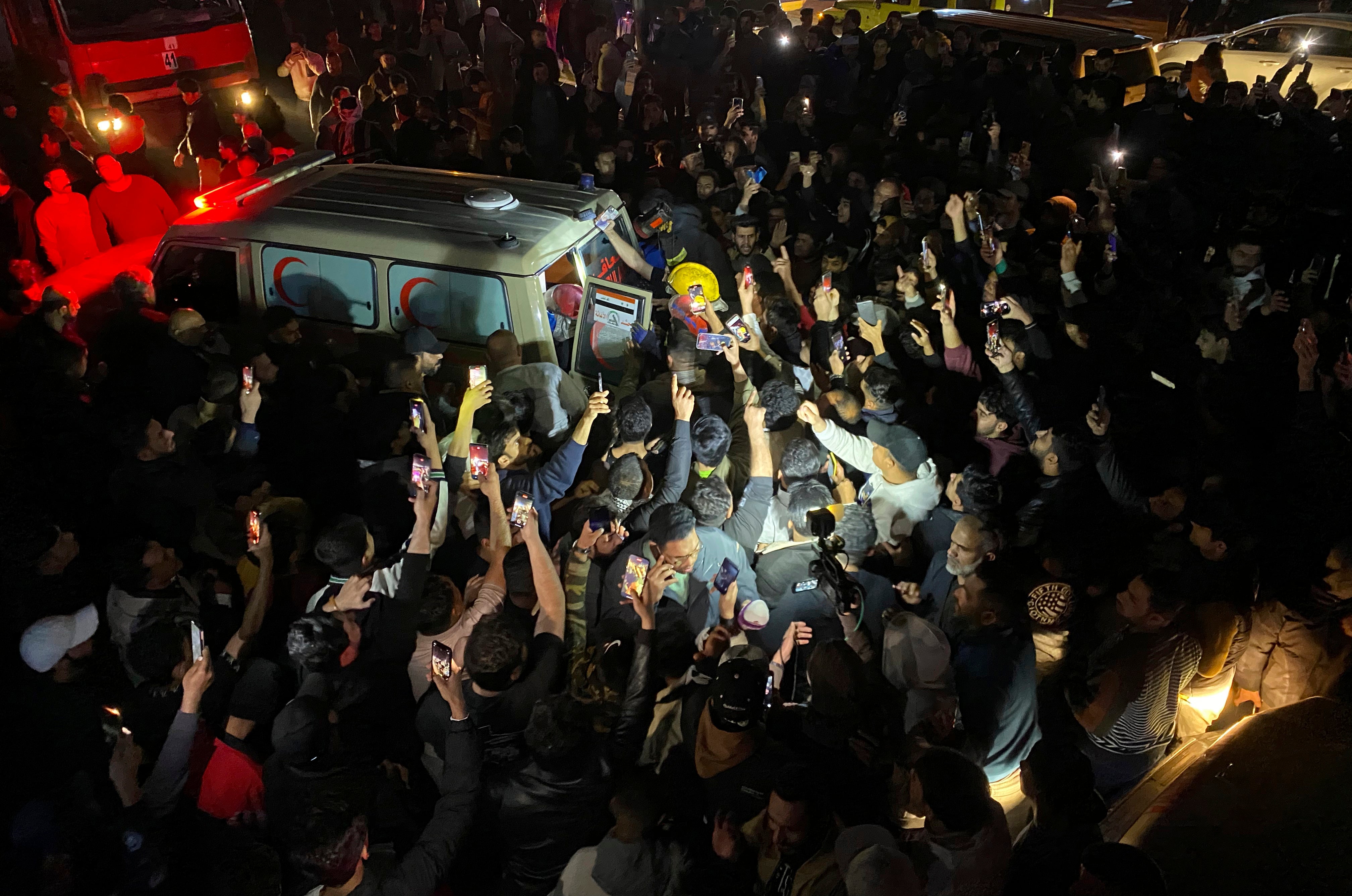 Iraqis gather at the site of a burned vehicle targeted by a U.S. drone strike in east Baghdad, Iraq, Wednesday 7 February 2024. (AP Photo/Hadi Mizban)