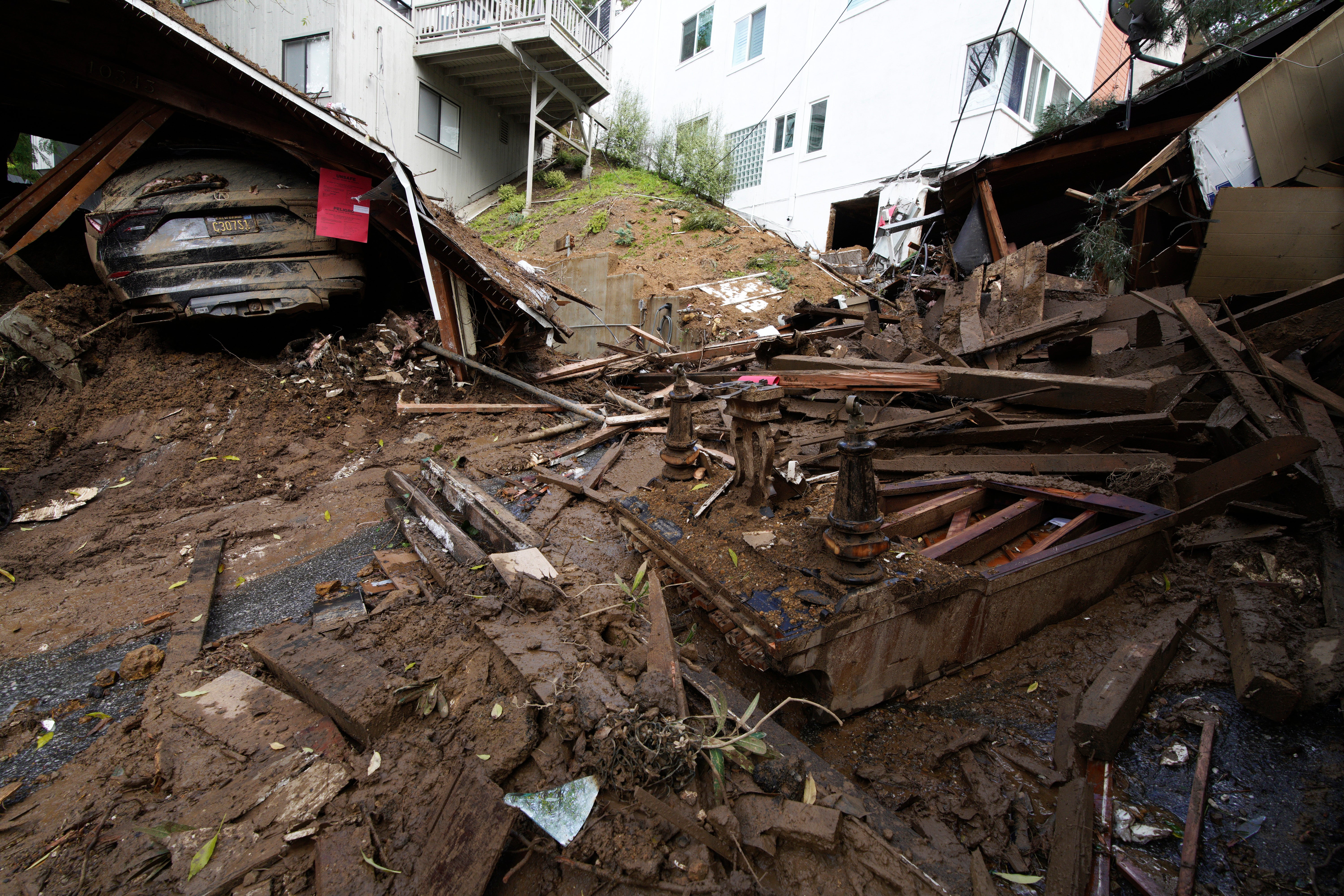 The remains of a piano and a collapsed carport are what's left of a house demolished by mud flows caused by heavy rains in the Beverly Glen section of Los Angeles