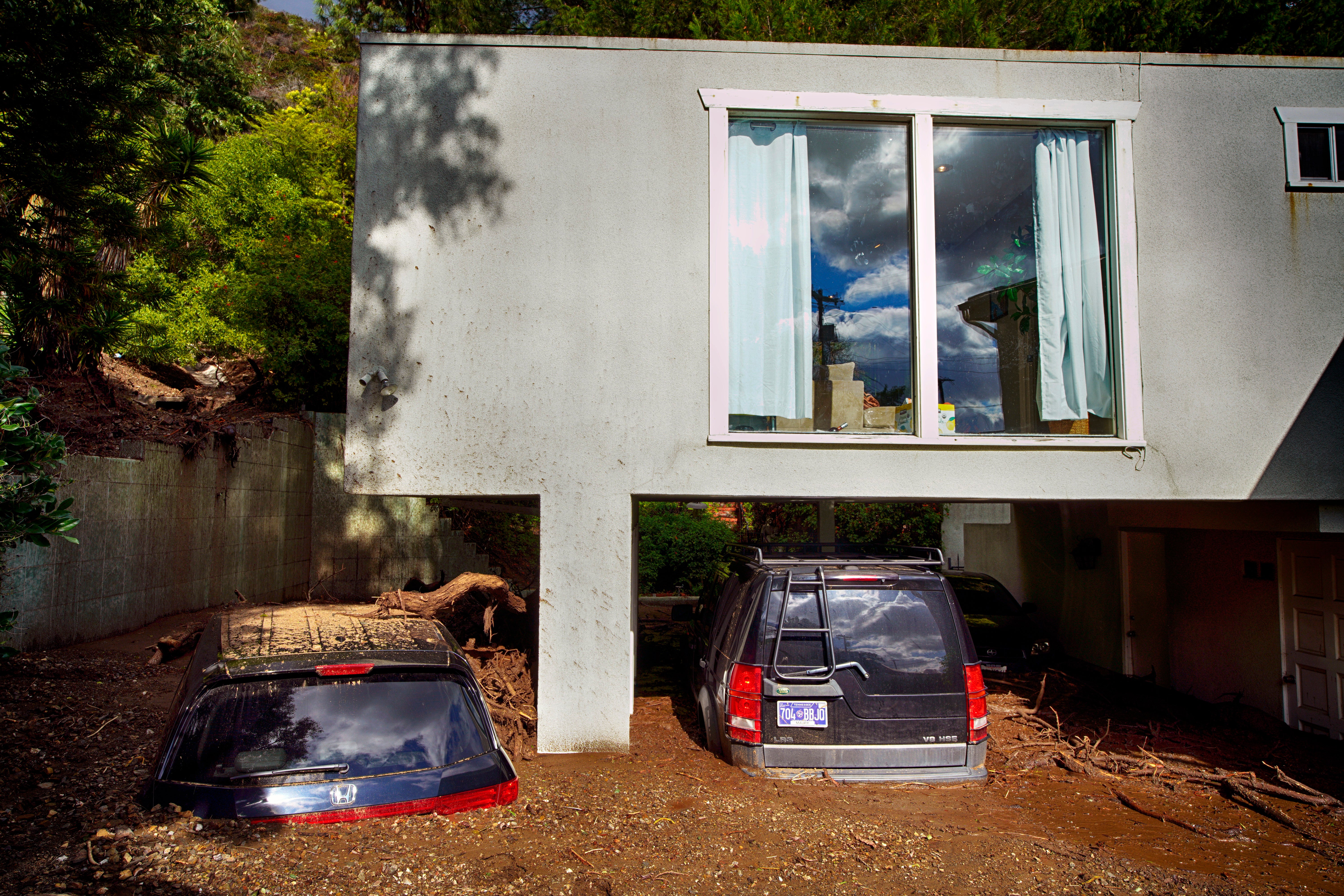 Cars are seen buried by mud in the garage of a home in Los Angeles on Wednesday, Feb. 7, 2024