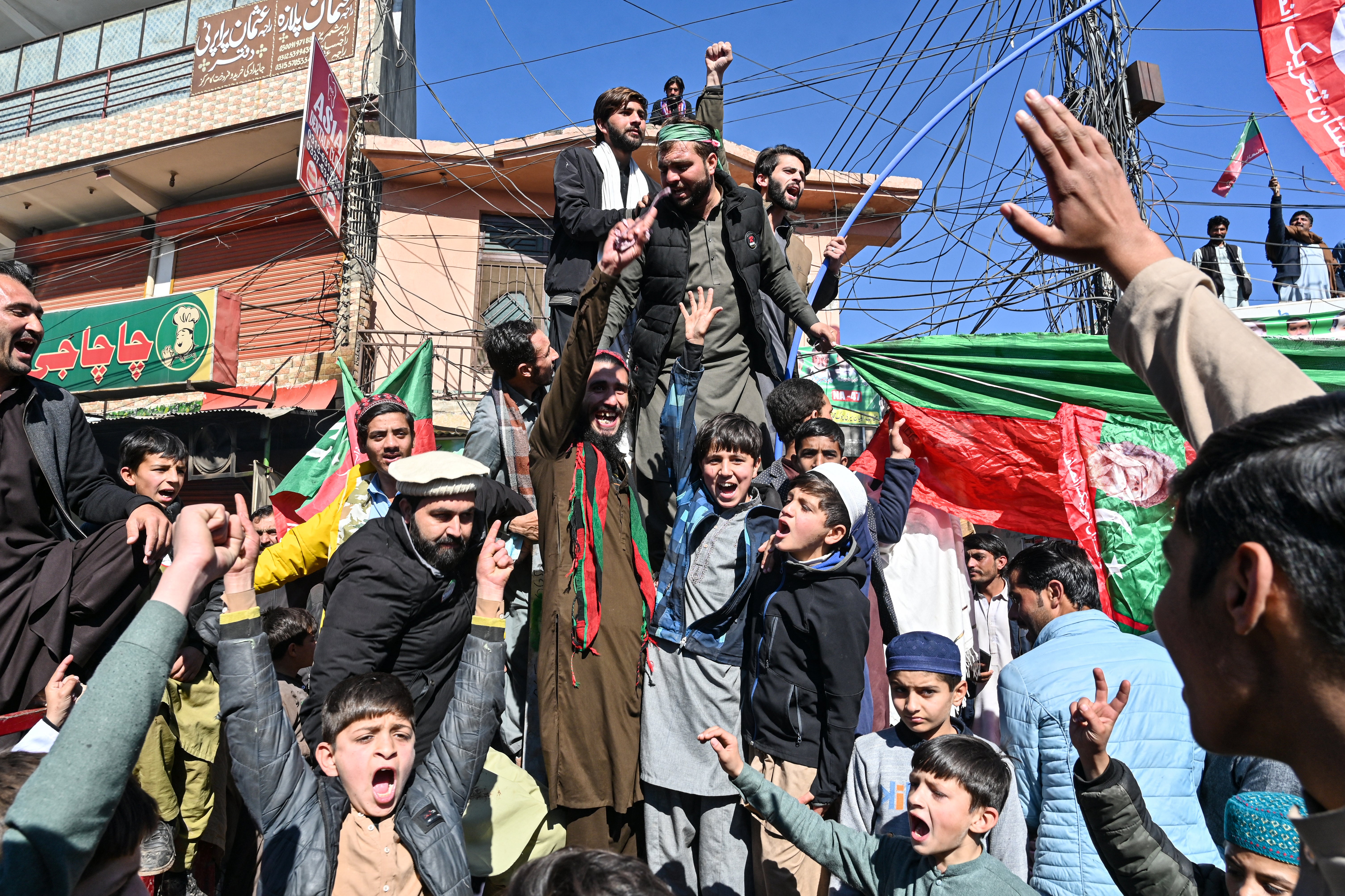 Activists of the Pakistan Tehreek-e-Insaf (PTI) party gather outside a polling station during Pakistan’s national election in Islamabad