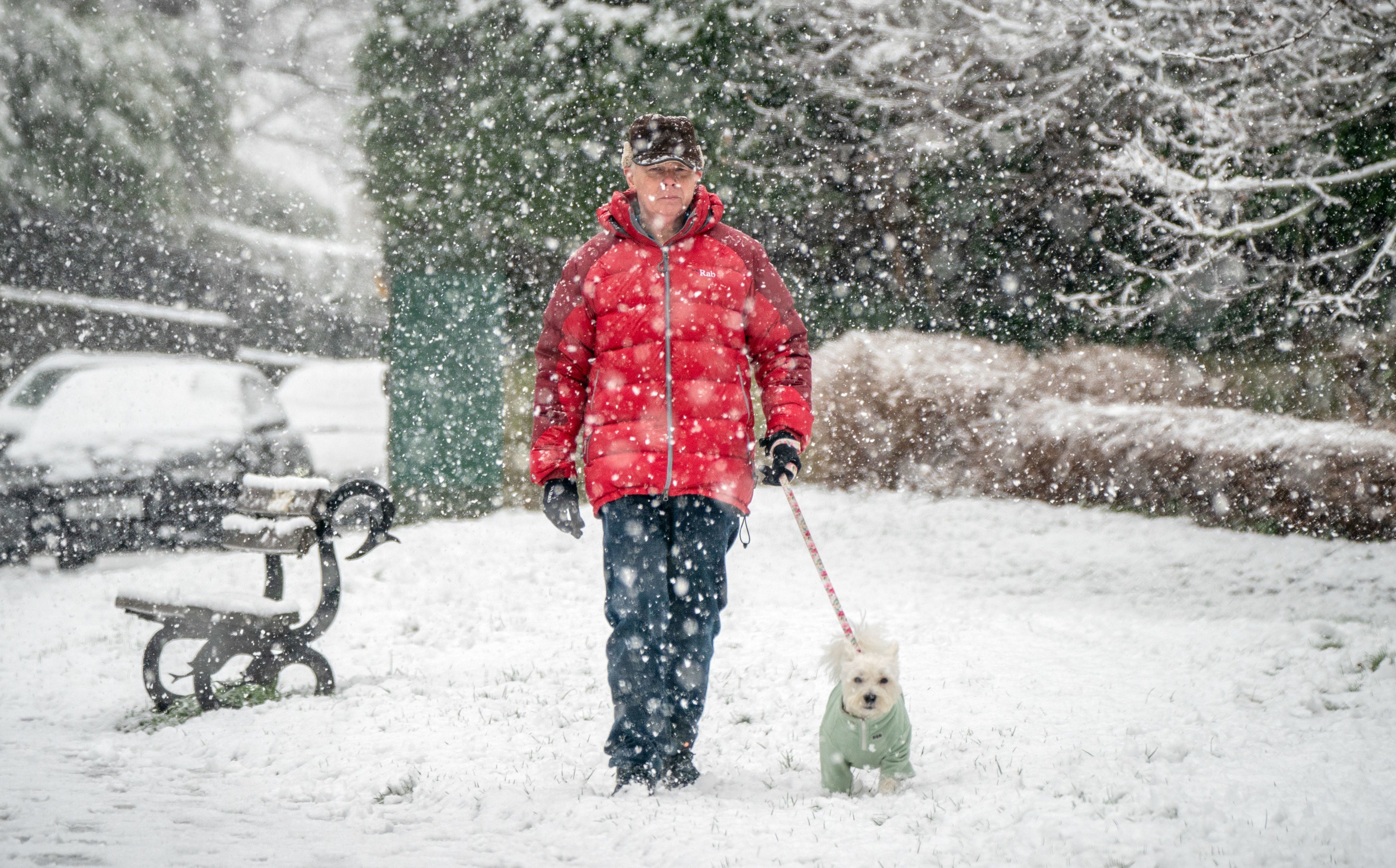 A man walks his dog in the snow in North Yorkshire